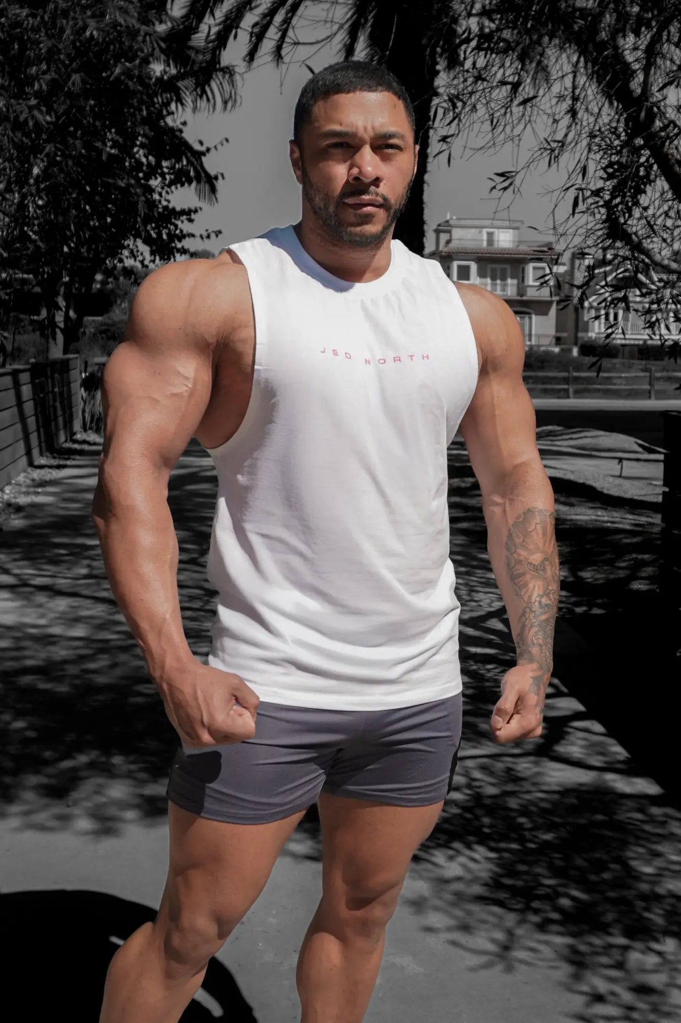 White sleeveless athletic tank top with red zed north text across the chest ideal for training and workouts