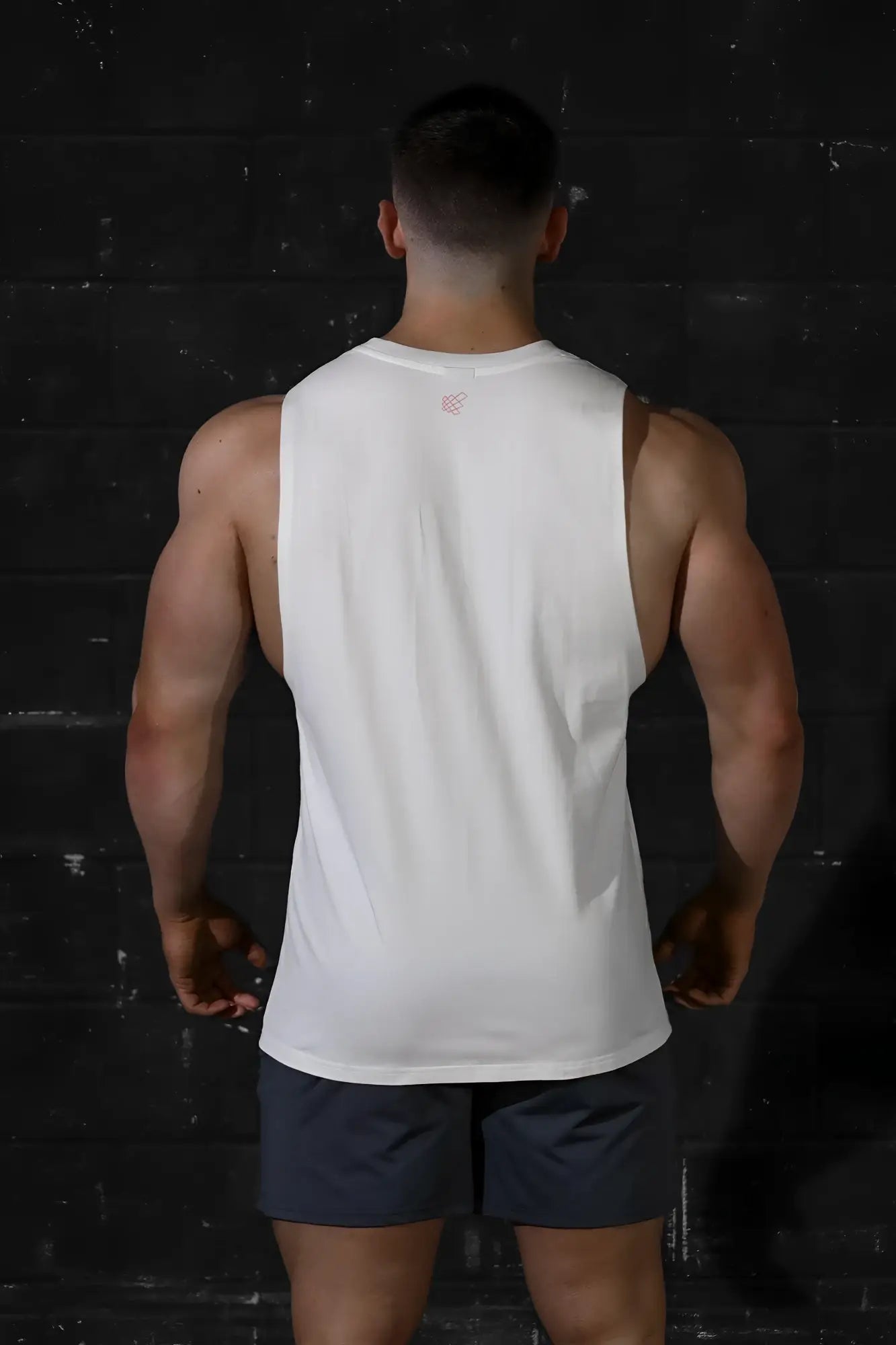 Jed north apollo men’s white sleeveless training tee with subtle pink logo at neckline perfect for workouts