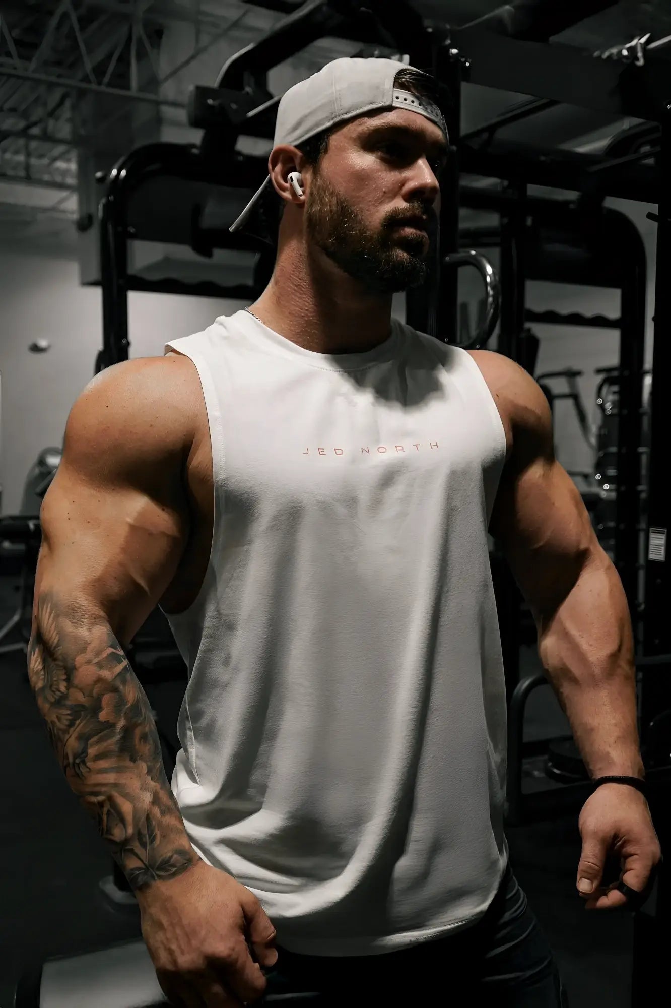 White sleeveless athletic tank top with subtle pink lettering across the chest from jed north apollo mens training tee