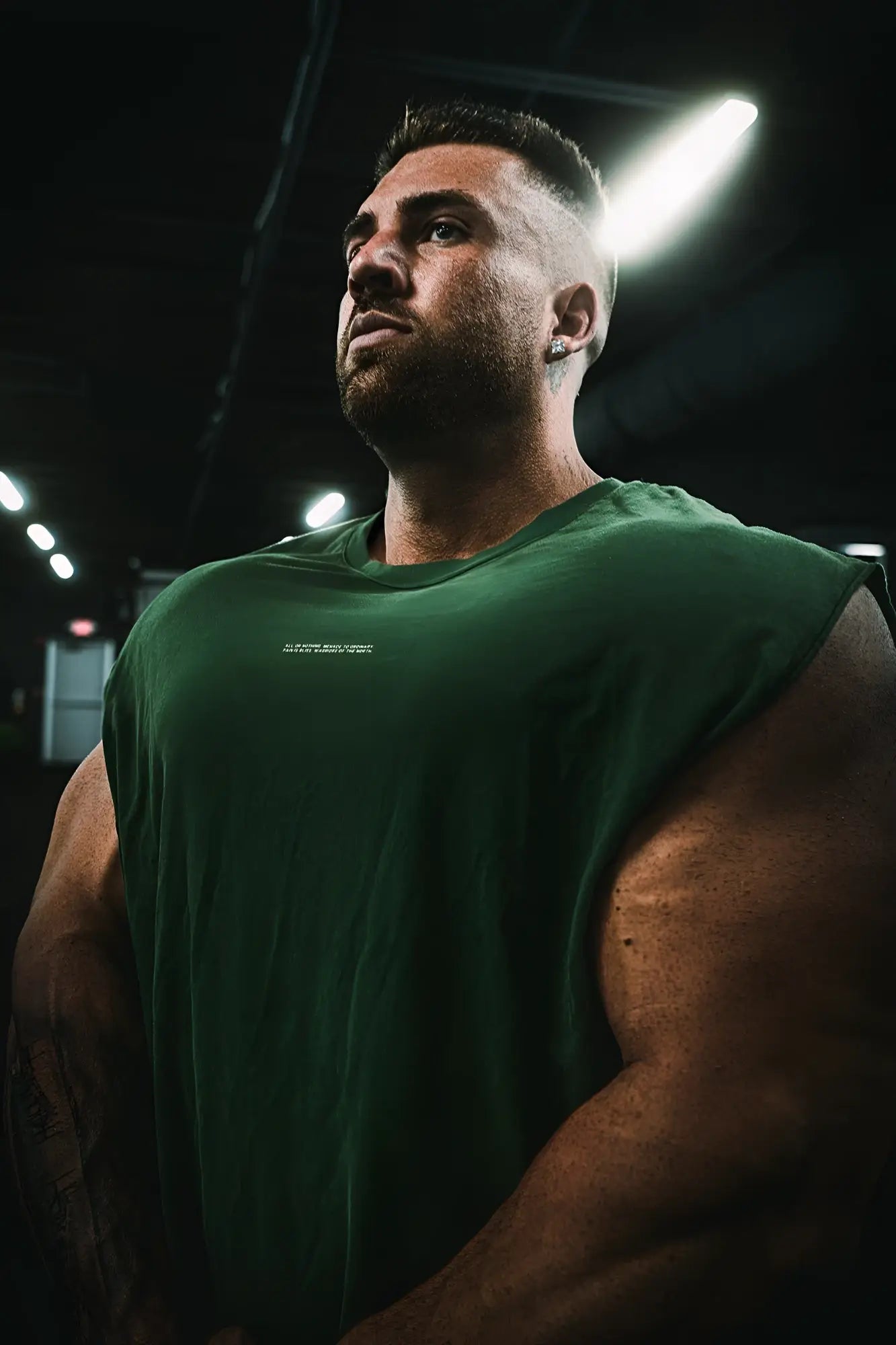 A dark green forest green box cut muscle tee sleeveless athletic shirt with a subtle chest logo