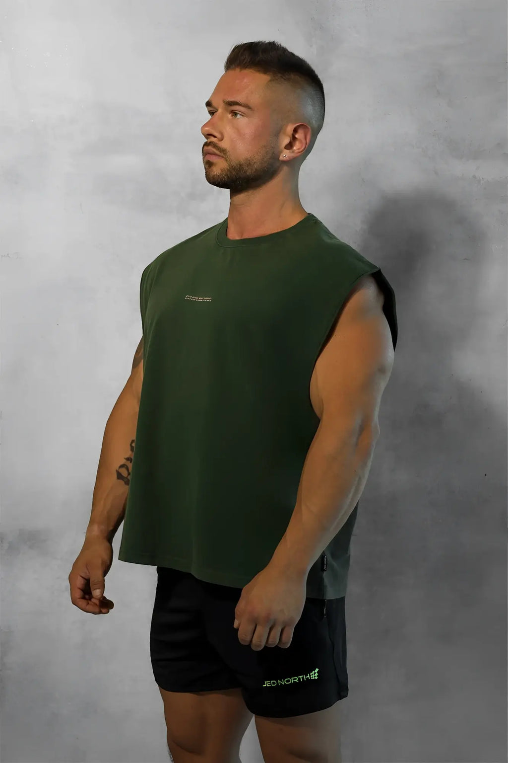 Dark green forest green box cut muscle tee sleeveless t-shirt with a subtle chest logo for casual wear