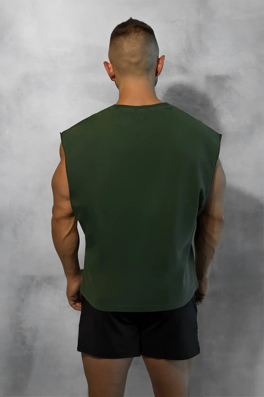 Dark green sleeveless box cut muscle tee with a simple crew neckline and relaxed fit for casual wear