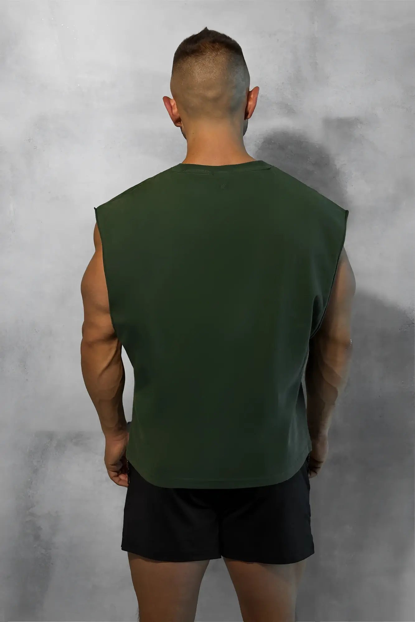 Dark green sleeveless box cut muscle tee with a simple crew neckline and relaxed fit for casual wear