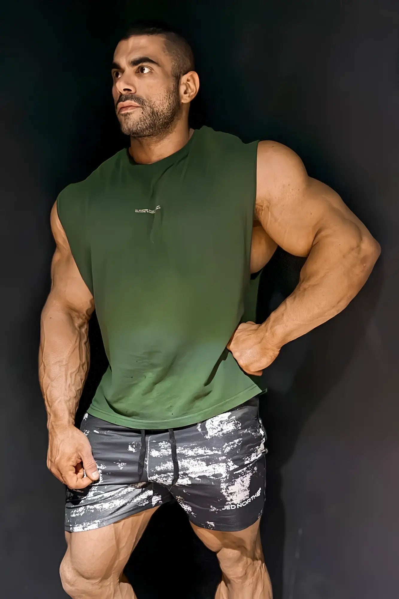 Olive green sleeveless box cut muscle tee with subtle chest logo designed for athletic wear