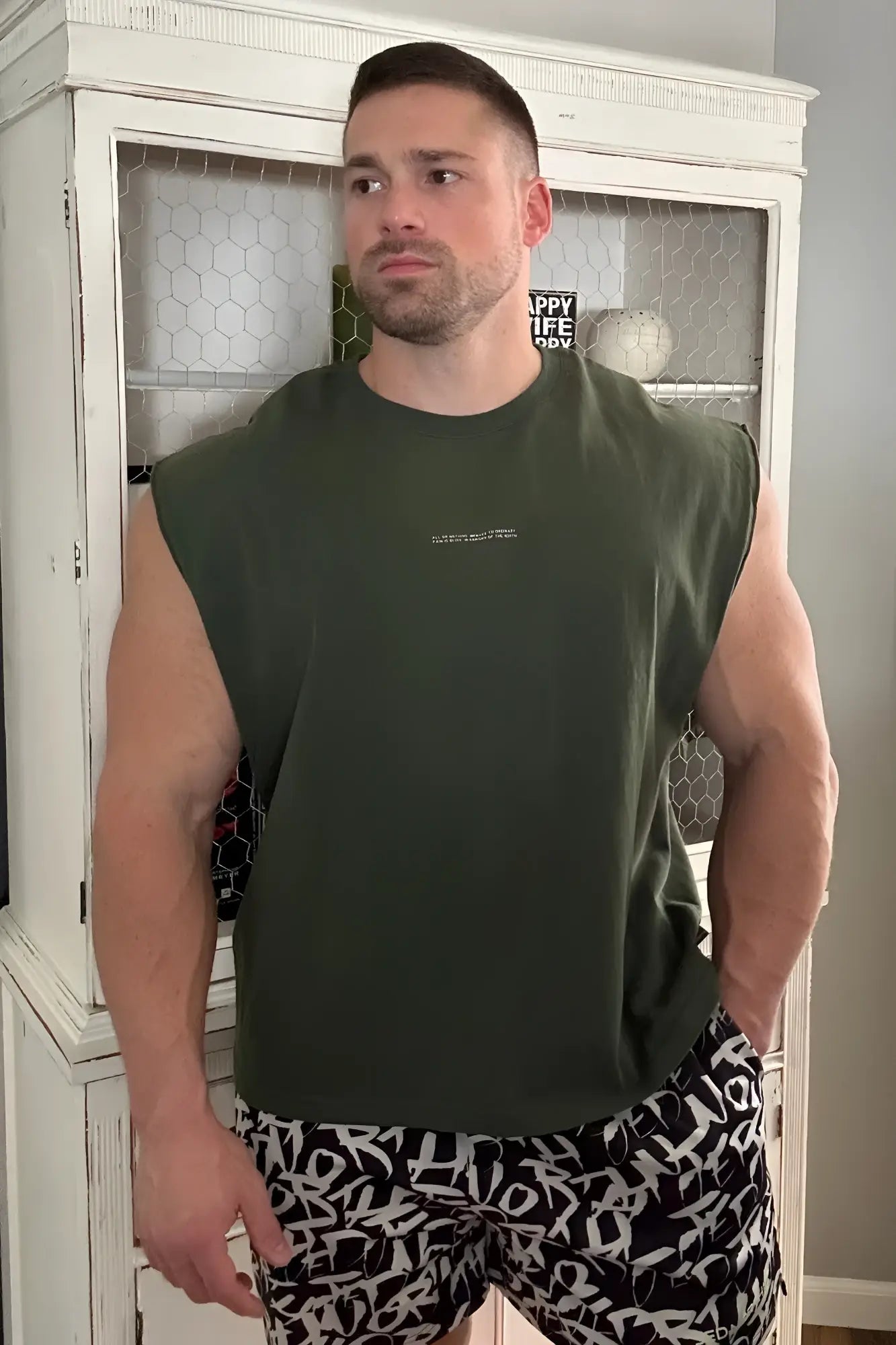 Box cut muscle tee forest green sleeveless olive green t-shirt with small white text logo on the chest