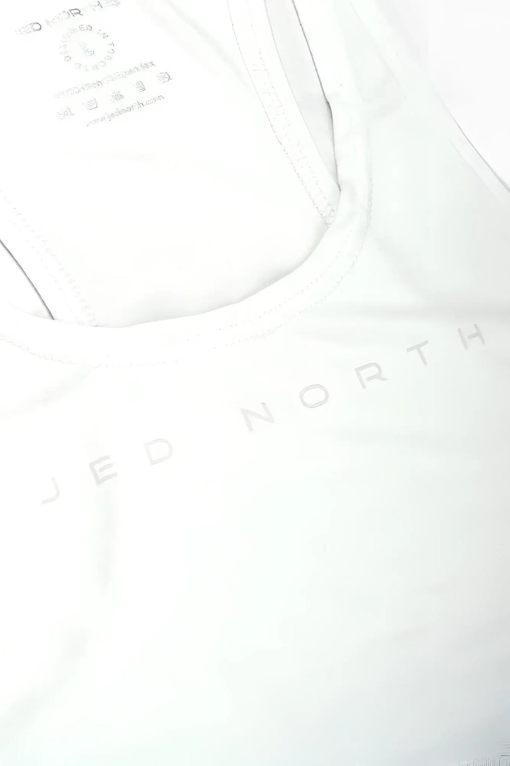 White tank top with jed north printed in light gray across the chest matching classic bodybuilding racerback stringer black ombre