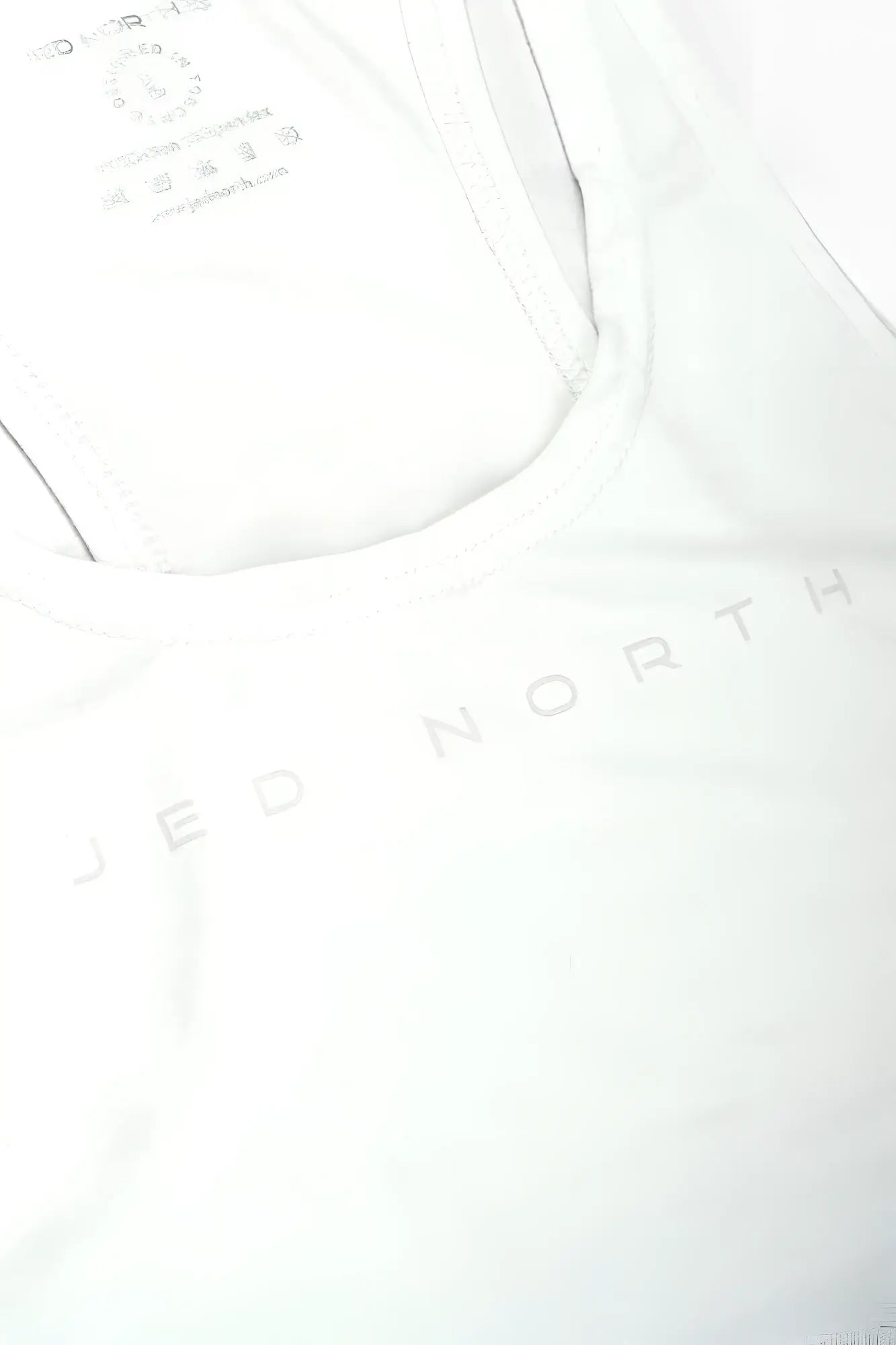 White tank top with jed north printed in light gray across the chest matching classic bodybuilding racerback stringer black ombre