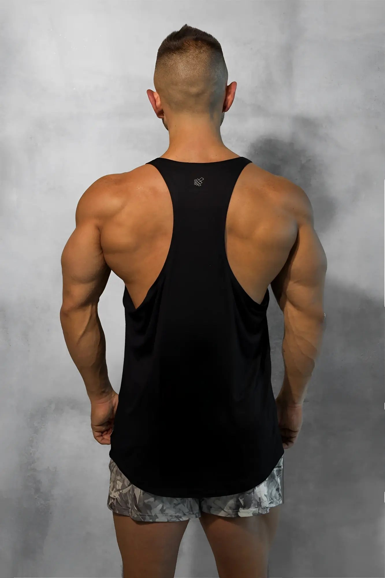 Black classic bodybuilding racerback stringer tank top with subtle logo at the neckline for workout wear