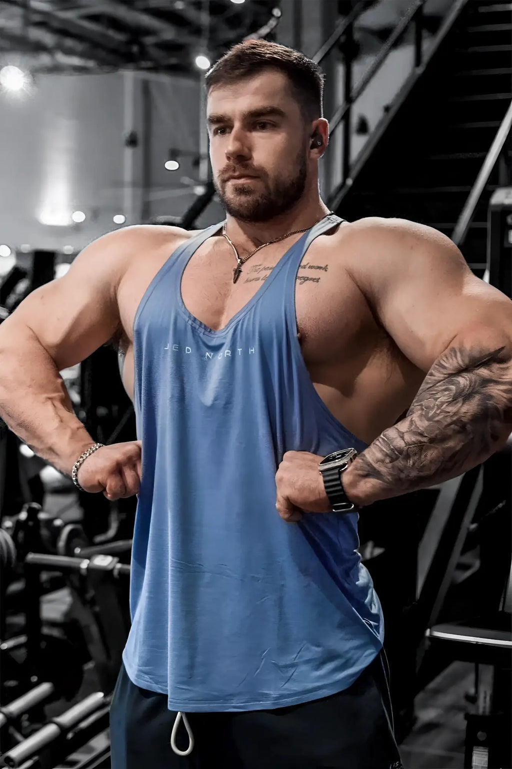 Blue sleeveless v-neck athletic tank top with subtle white lettering by Jed North for bodybuilding and training