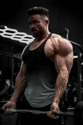Muscular man lifting weights wearing a gray ombre classic bodybuilding racerback stringer tank top in the gym