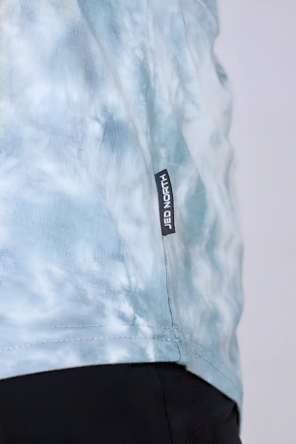 Light blue tie-dye cotton t-shirt with black jed north brand tag on seam for classic bodybuilding racerback stringer gray tie dye