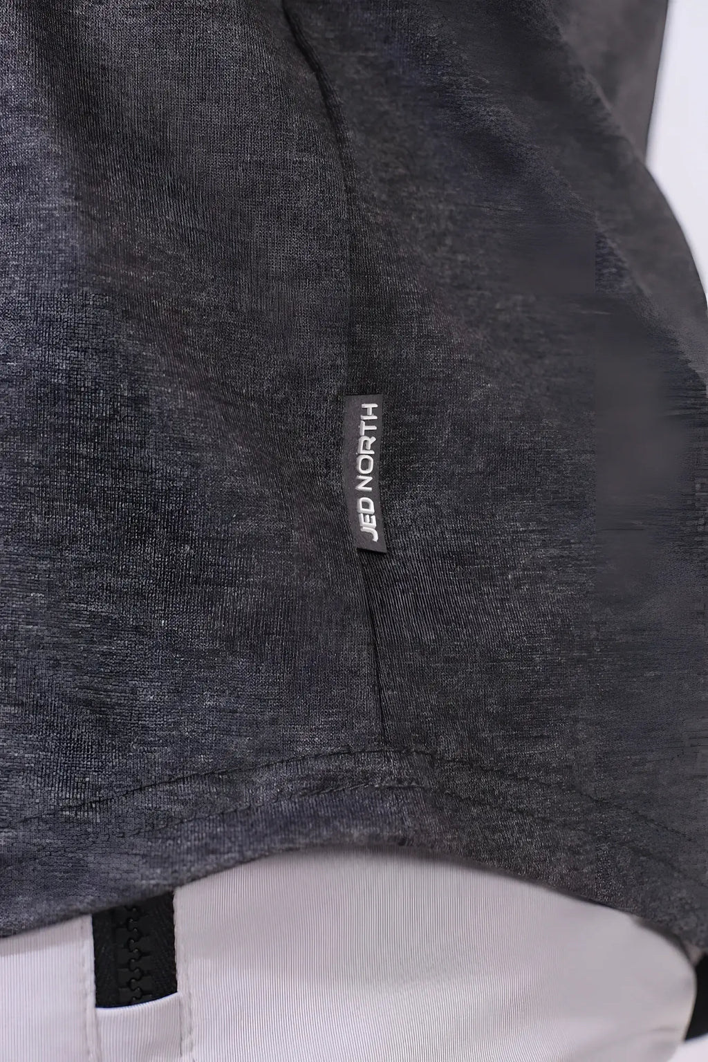 Dark gray heathered fabric of jed north classic bodybuilding racerback stringer with black brand tag near seam
