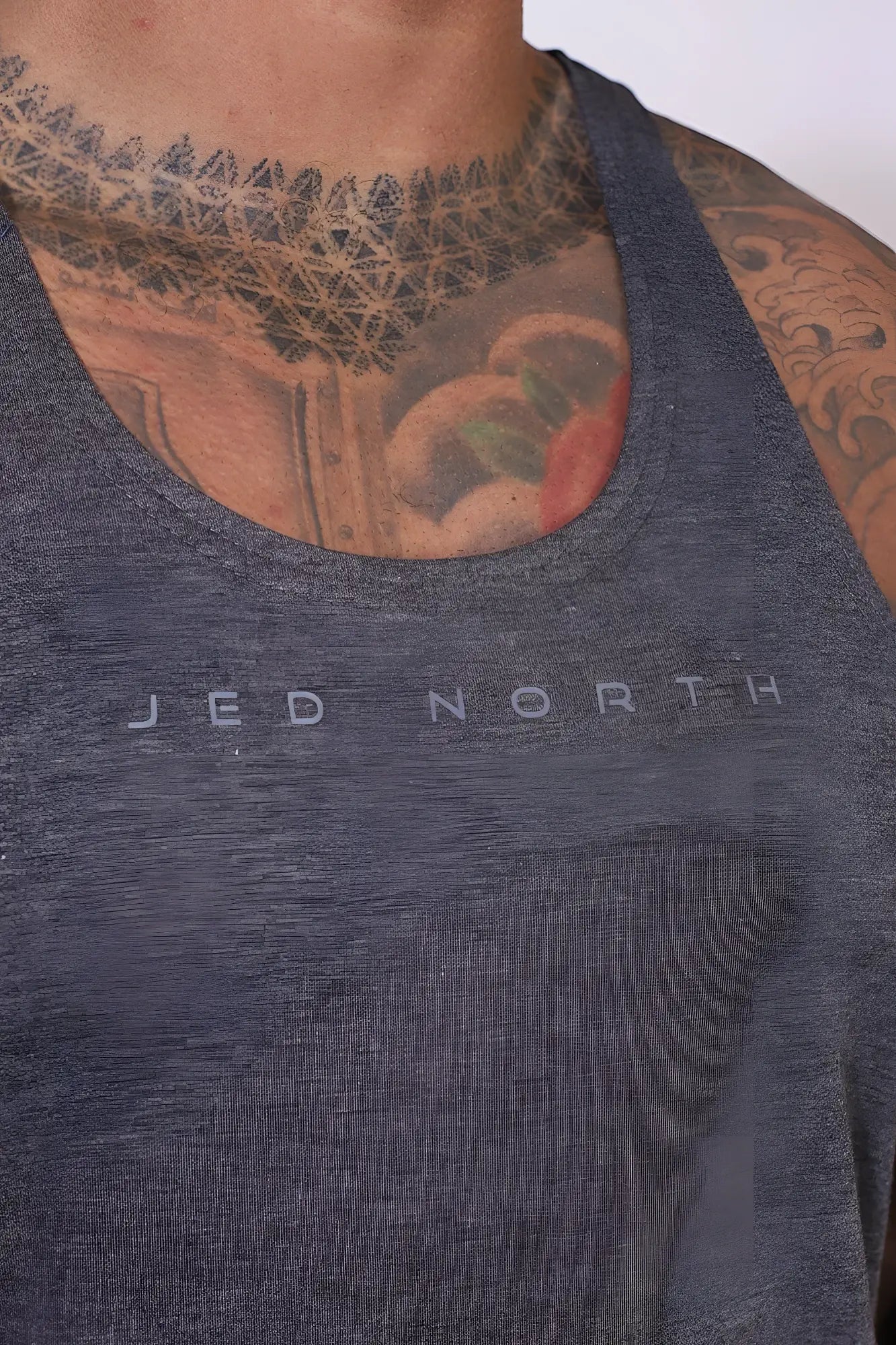 A dark heather gray jed north classic bodybuilding racerback stringer tank top with a subtle logo on the chest