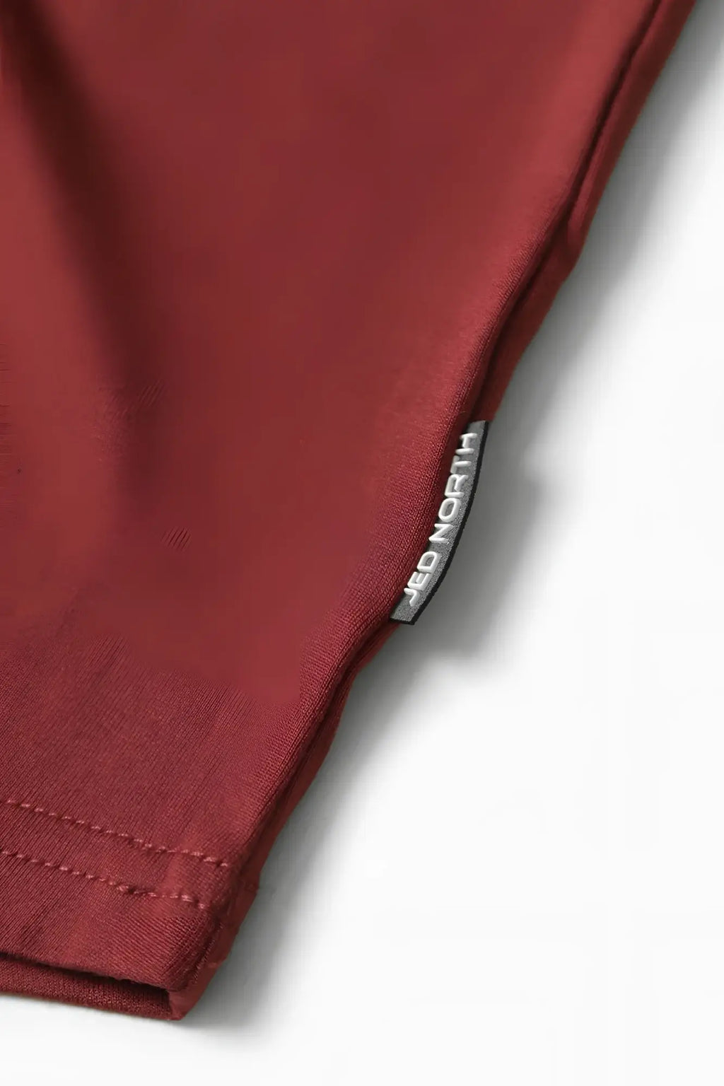 A maroon cotton classic bodybuilding racerback stringer with a silver Red North brand tag stitched in the seam