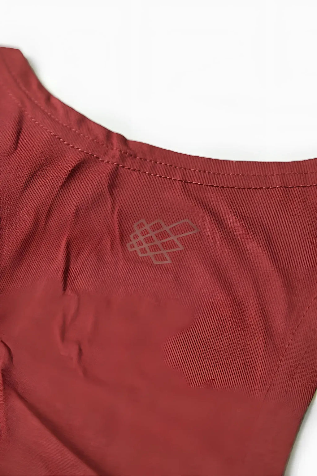 A soft rust-red cotton classic bodybuilding racerback stringer with a subtle embroidered geometric logo near the neckline