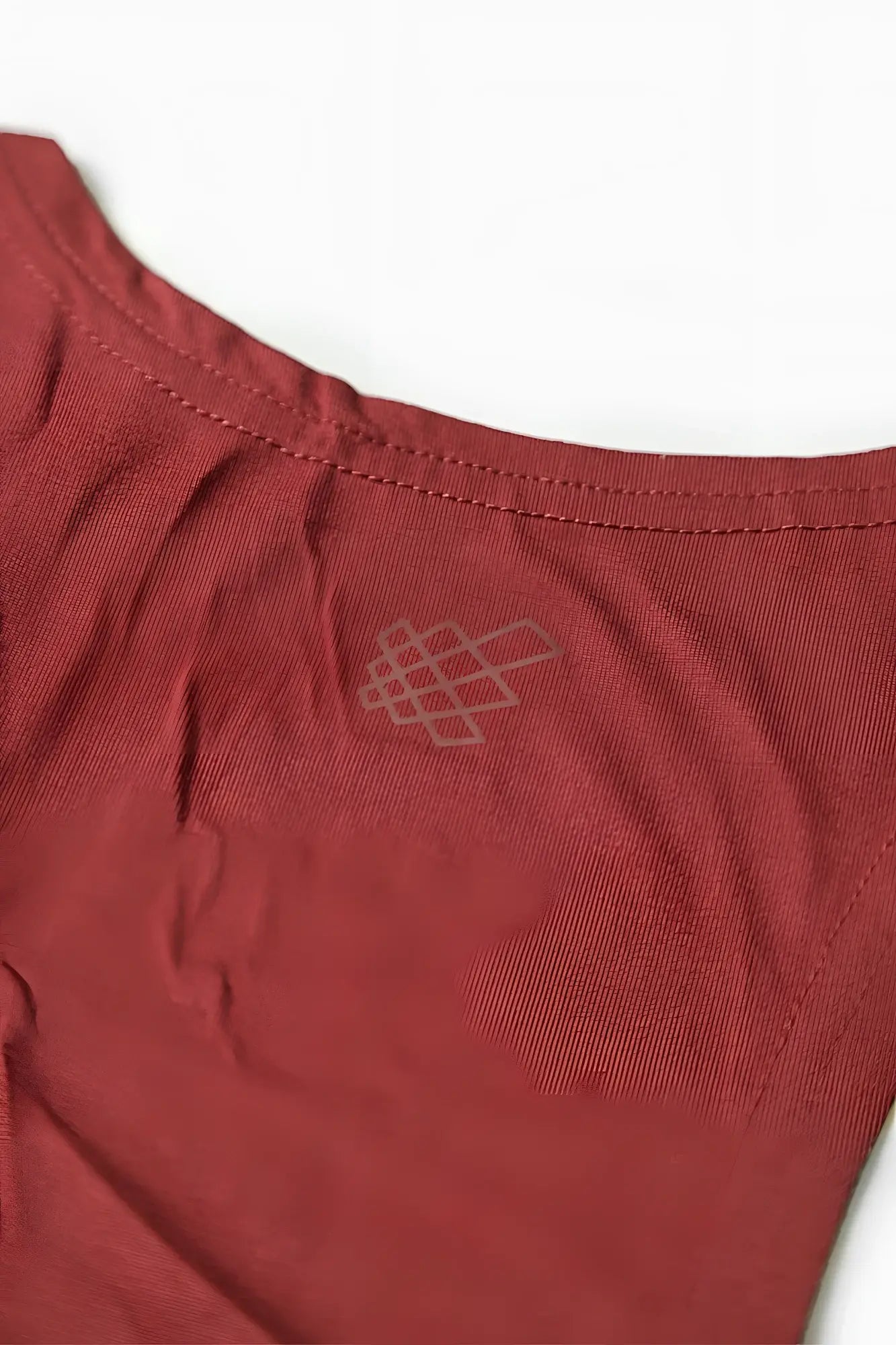 A soft rust-red cotton classic bodybuilding racerback stringer with a subtle embroidered geometric logo near the neckline
