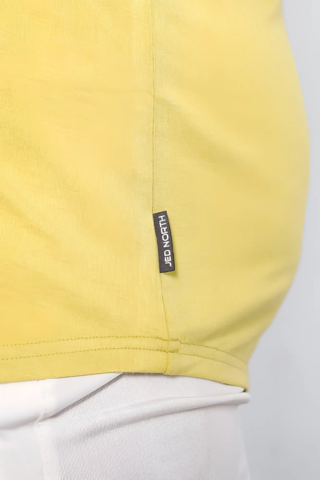 A vibrant yellow cotton jed north classic bodybuilding racerback stringer with a black brand tag near the hem