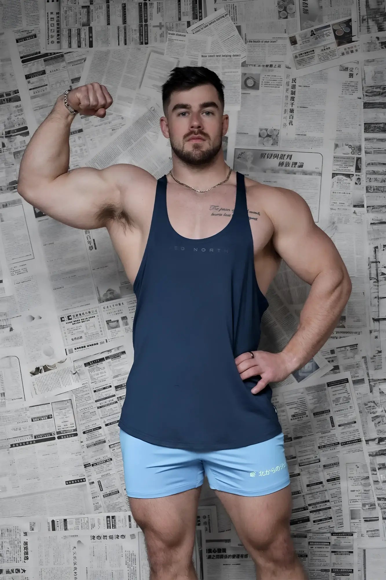 Navy blue sleeveless racerback stringer tank top with subtle logo across chest by Jed North for bodybuilding use