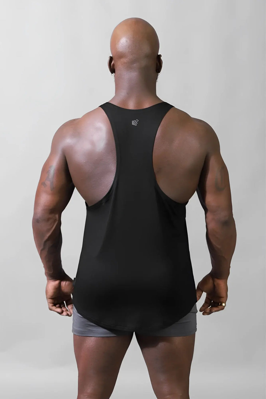 Back view of jed north classic bodybuilding racerback stringer tank top in premium black with small white logo