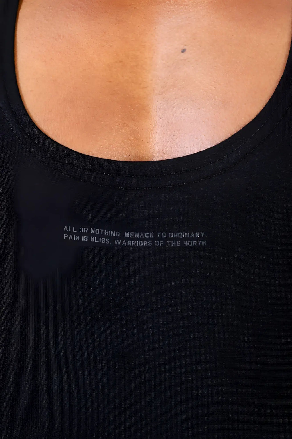 Black racerback tank top with subtle light gray embroidered phrase across the chest for classic bodybuilding use
