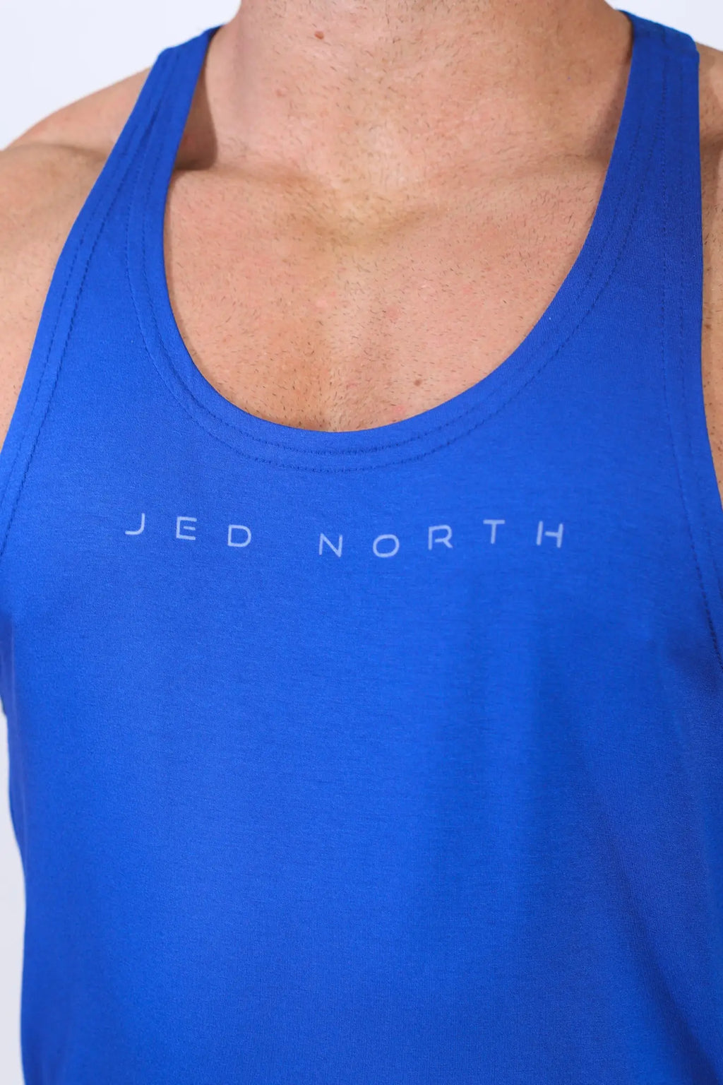 Bright blue royal blue classic bodybuilding racerback stringer tank top with subtle white jed north logo on chest