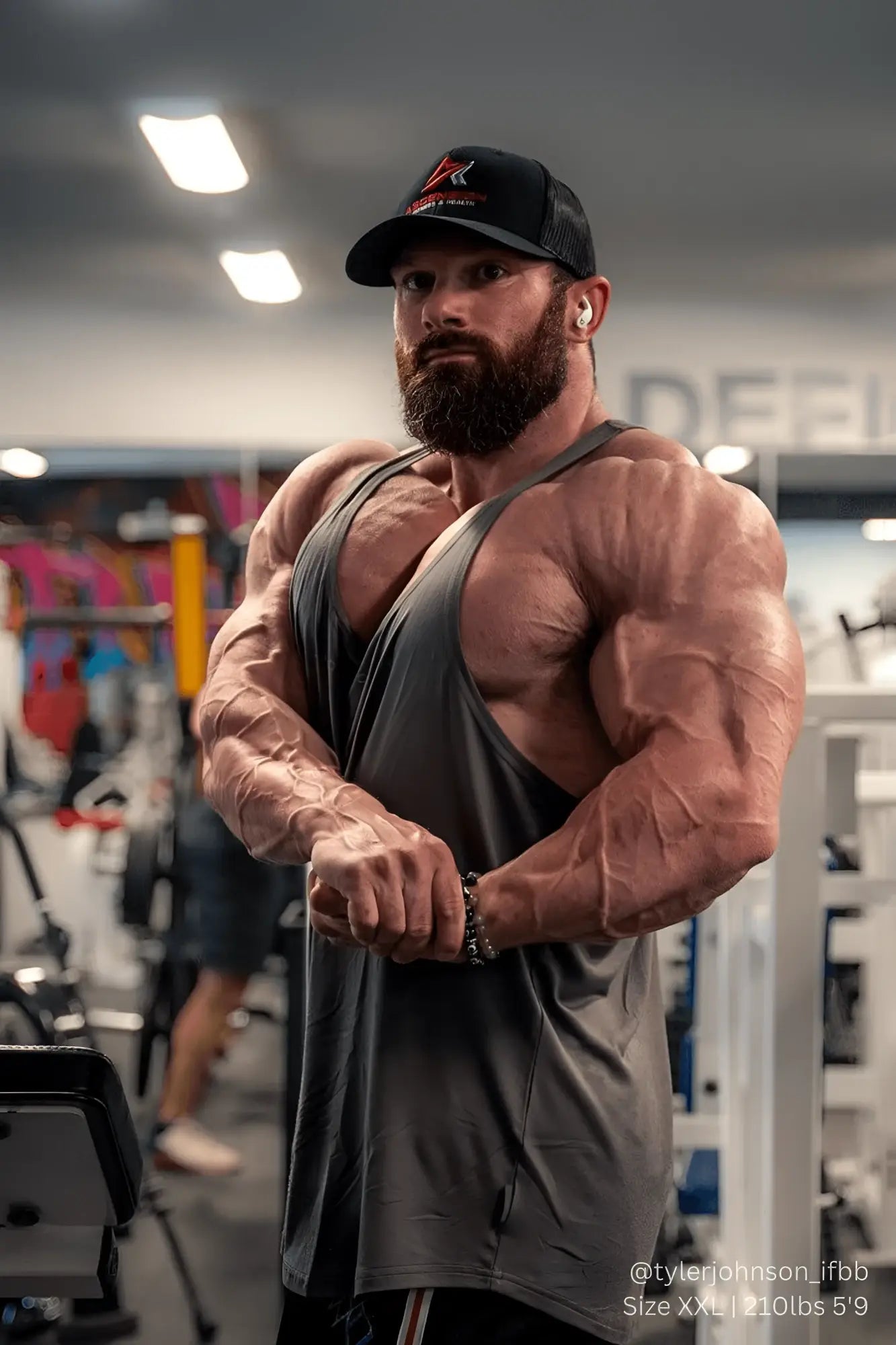 A muscular man wearing a jed north classic bodybuilding racerback stringer tank top in steel gray color