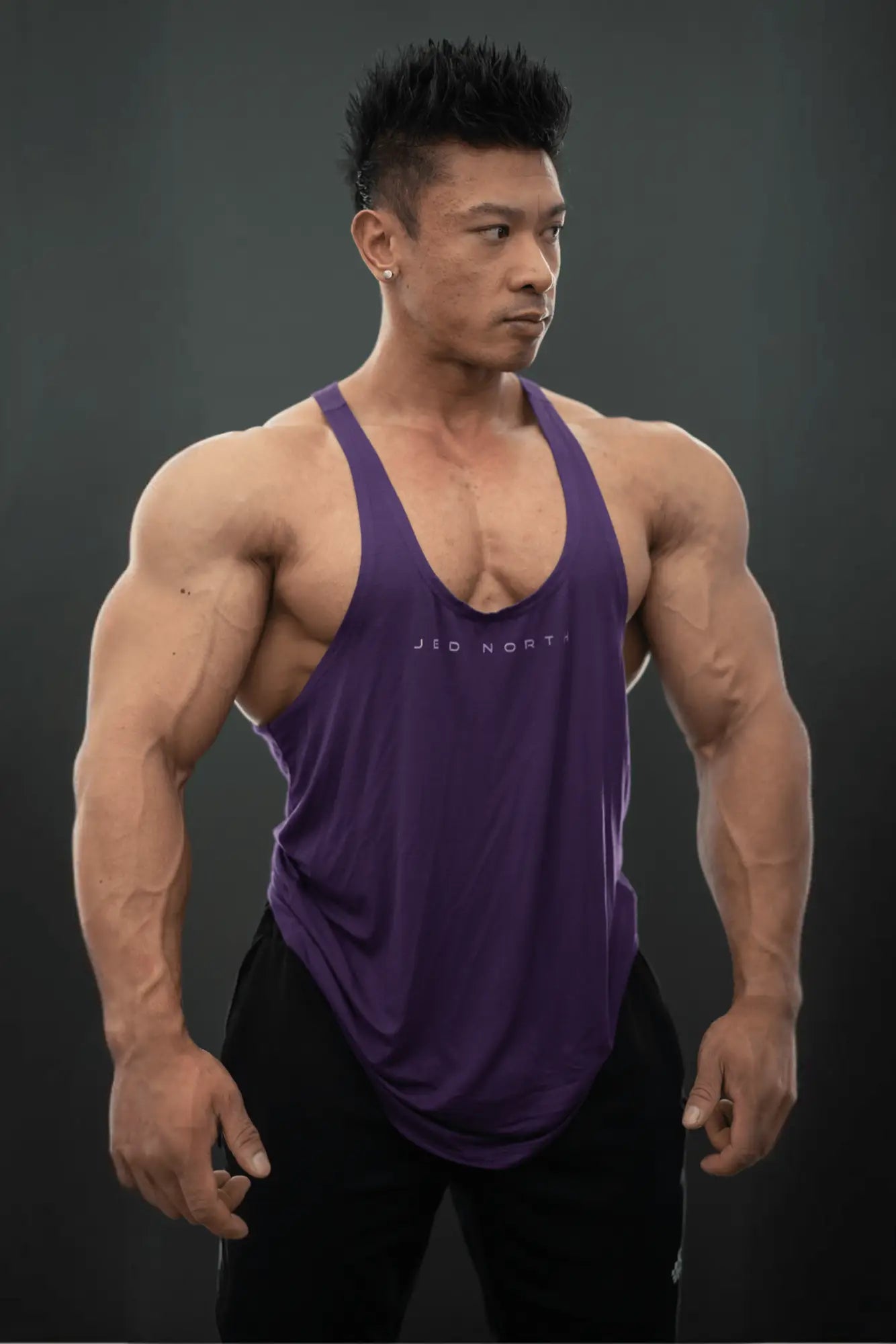 Purple sleeveless athletic tank top with deep v-neckline and subtle white lettering for bodybuilding workouts