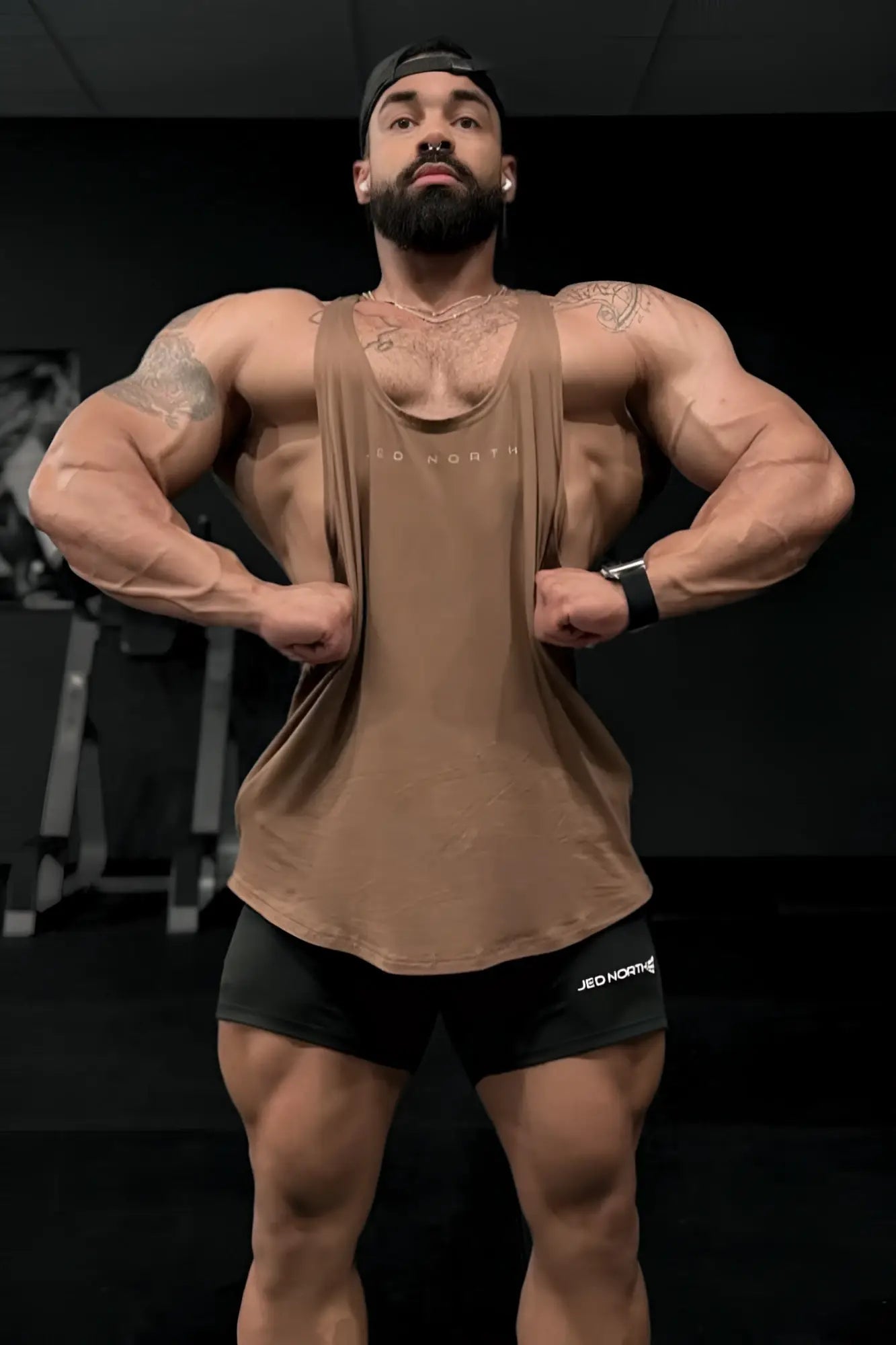 A tan sleeveless muscle tank top with subtle texture and jed north logo across the chest for bodybuilding