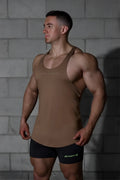 Tan sleeveless Jed North Classic bodybuilding racerback stringer with light branding paired with black shorts