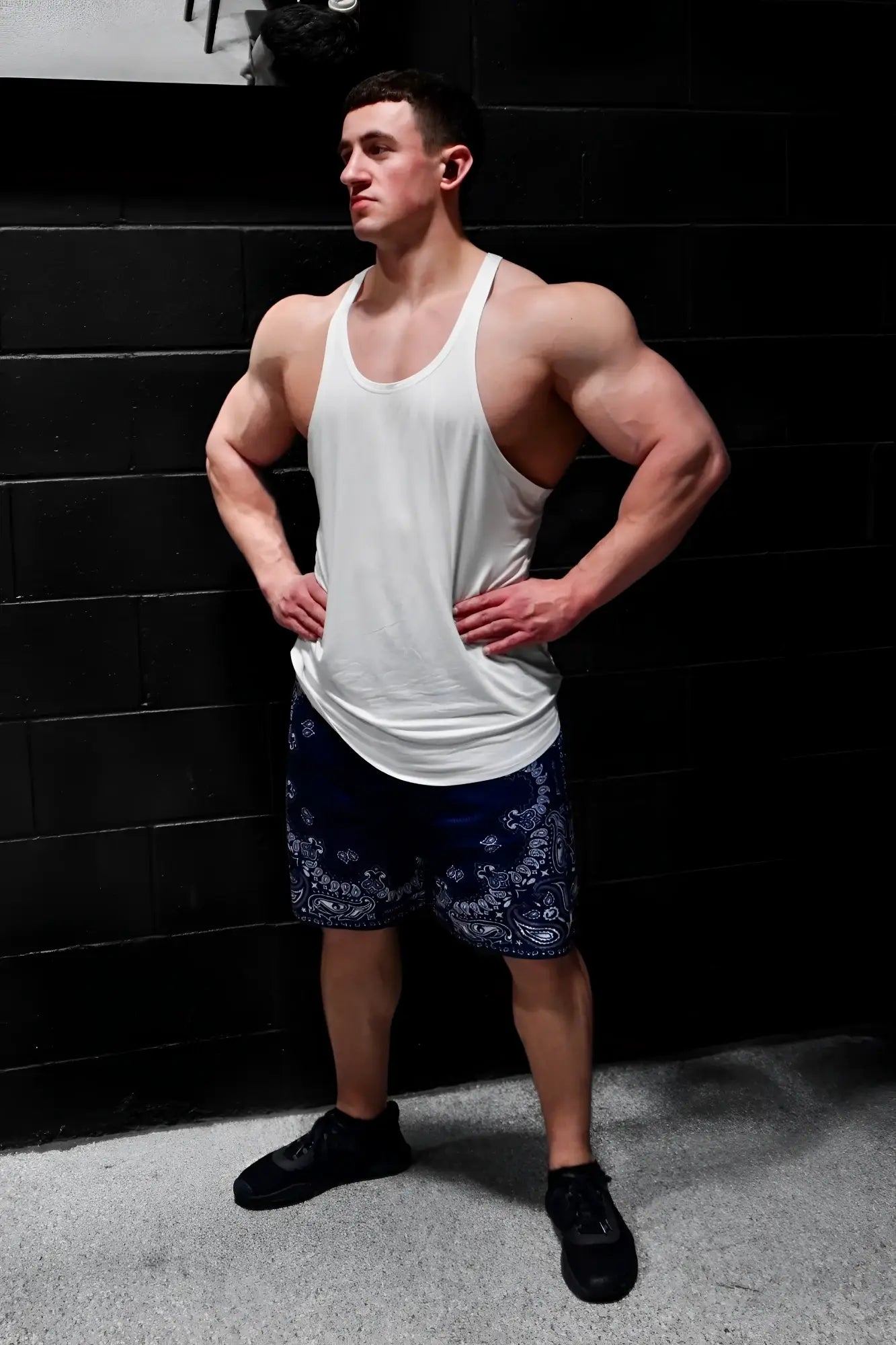 A white classic bodybuilding racerback stringer tank top with a relaxed fit and slightly loose hemline