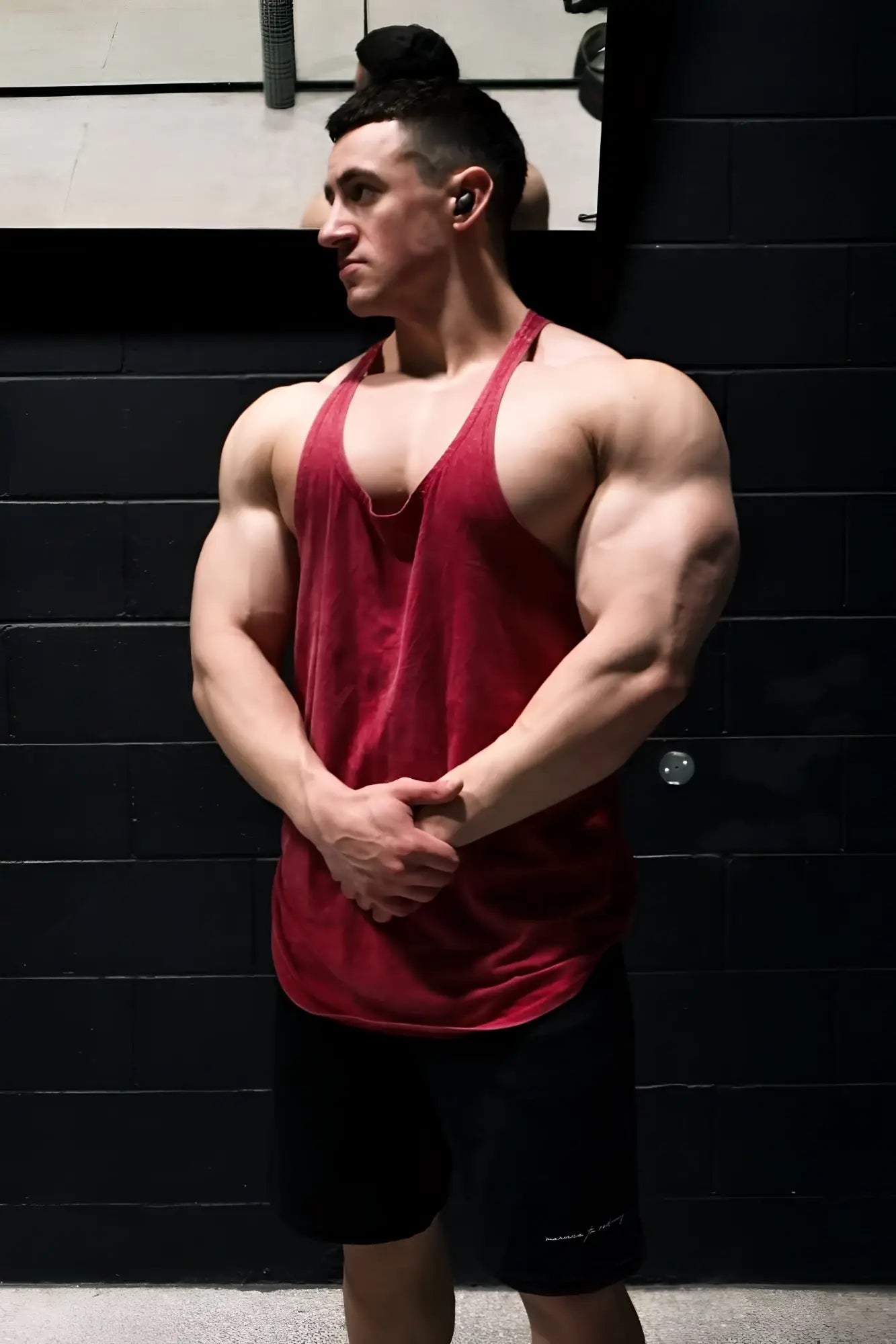 A man wearing a crimson jed north classic vintage washed racerback stringer muscle tank top with faded fabric