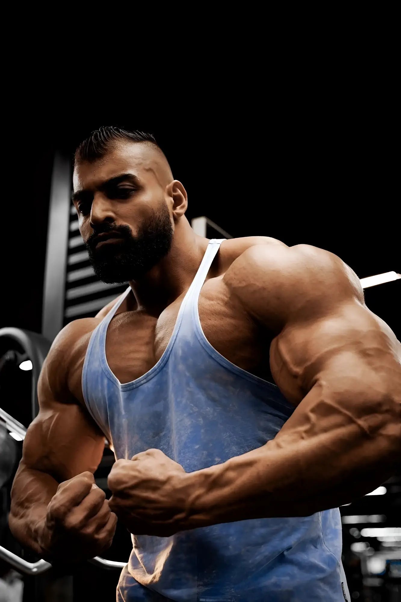 A man wearing a faded blue classic vintage washed racerback stringer tank top in sky blue for athletic use