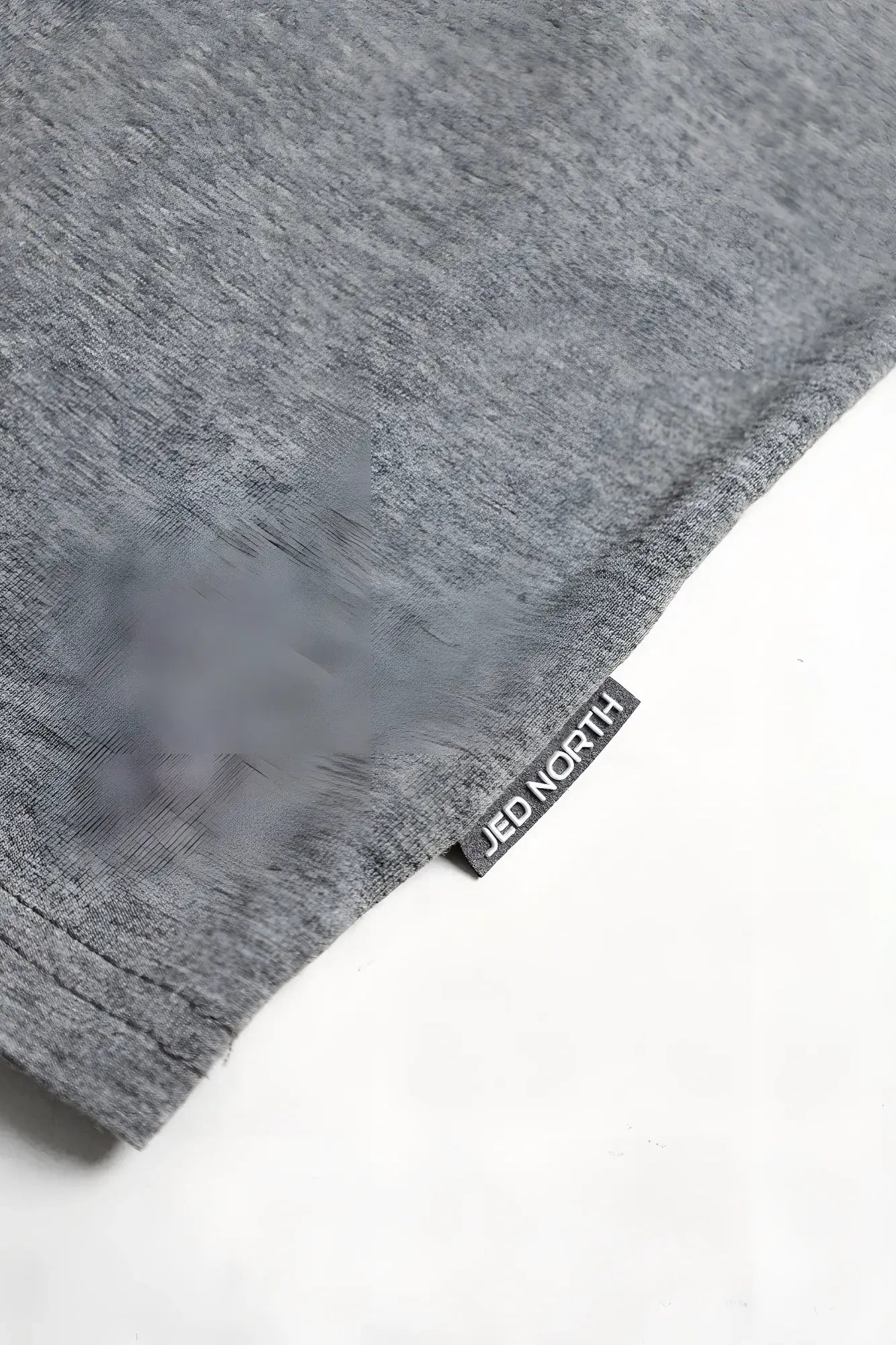 Gray heathered cotton training stringer t-shirt with black woven jed north brand tag at the hem