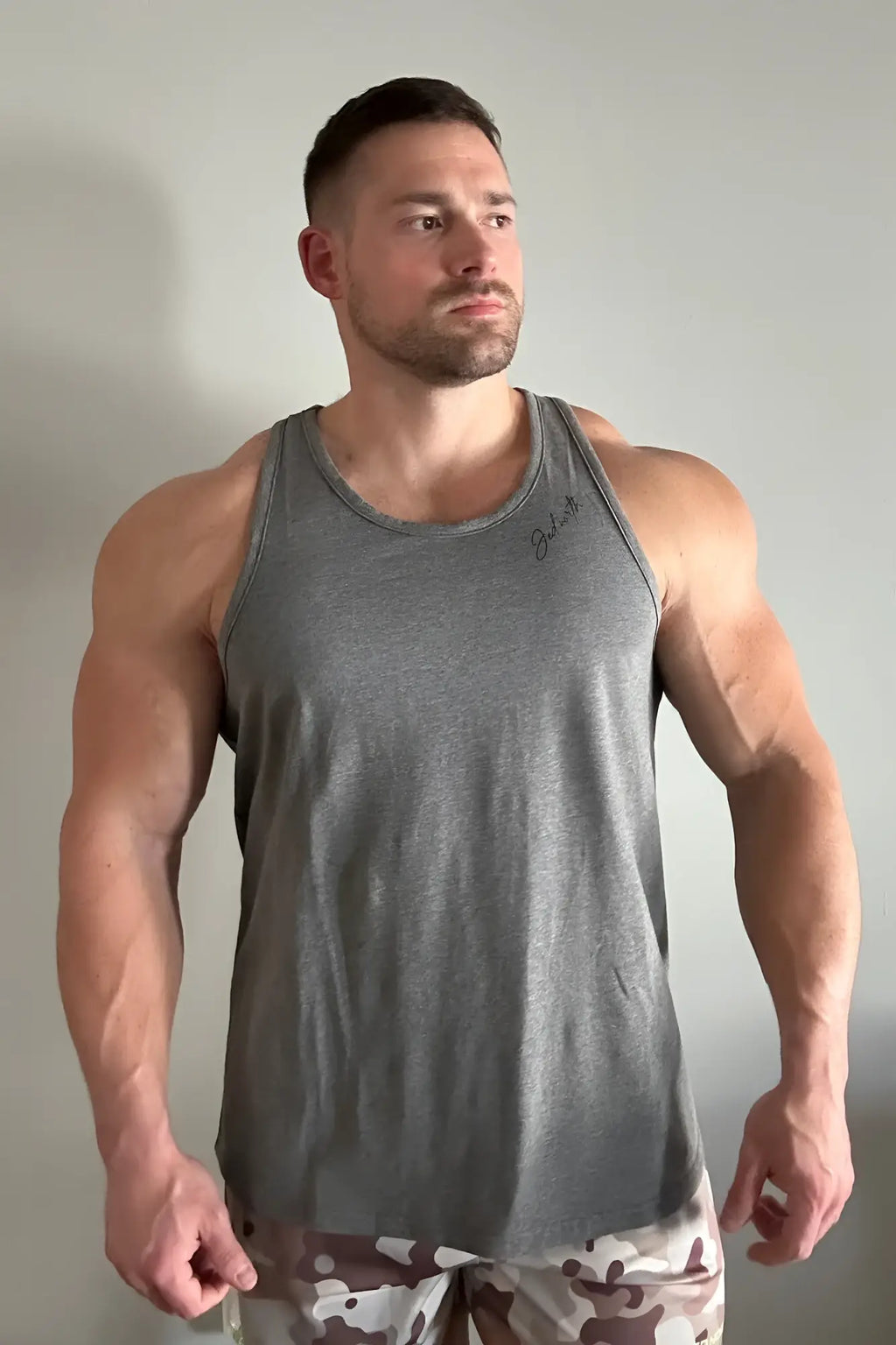 Gray heathered cotton training stringer tank top with subtle embroidered signature on left chest