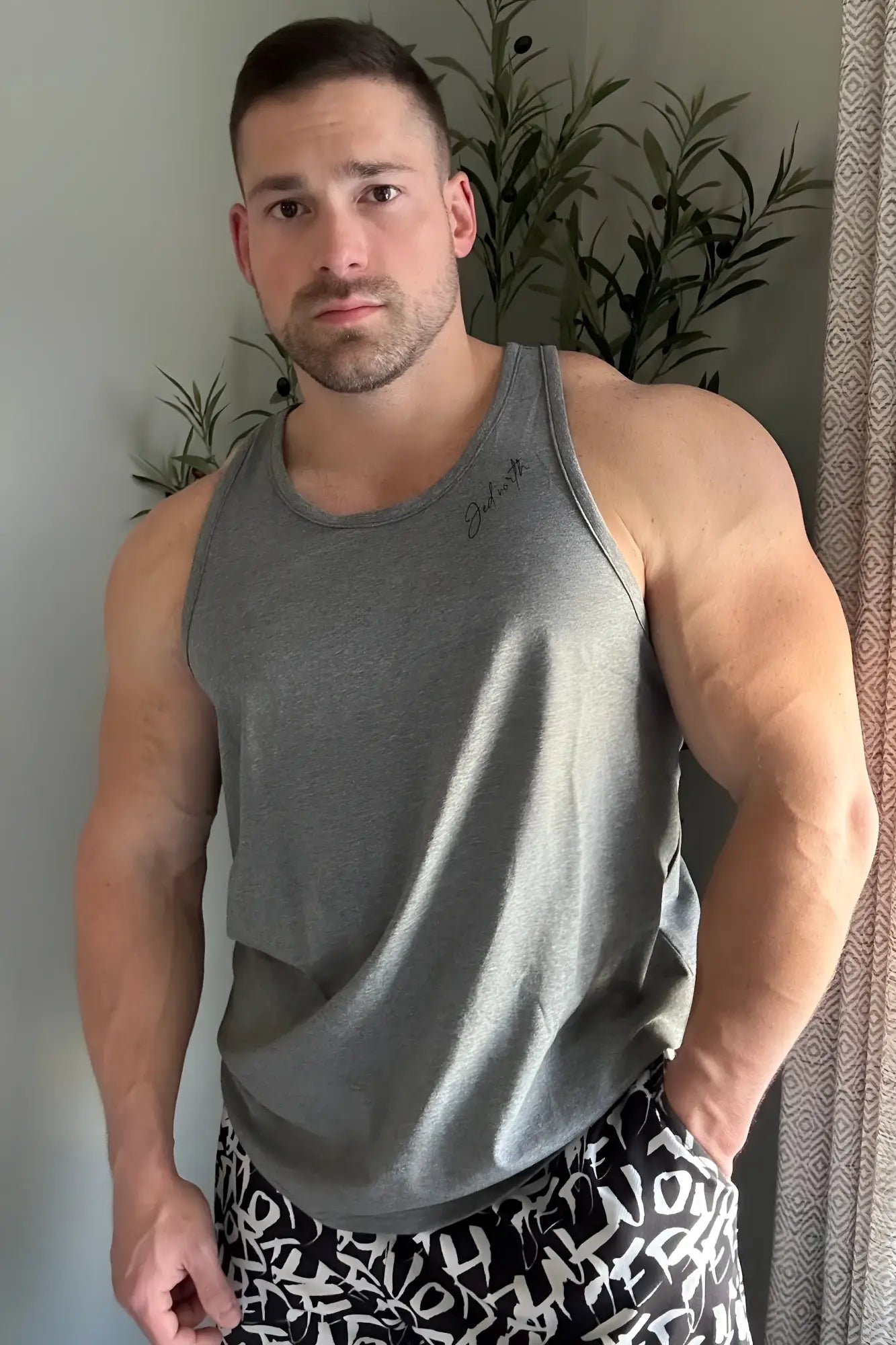 Gray heathered cotton training stringer tank top with subtle signature embroidery on the left chest for workouts