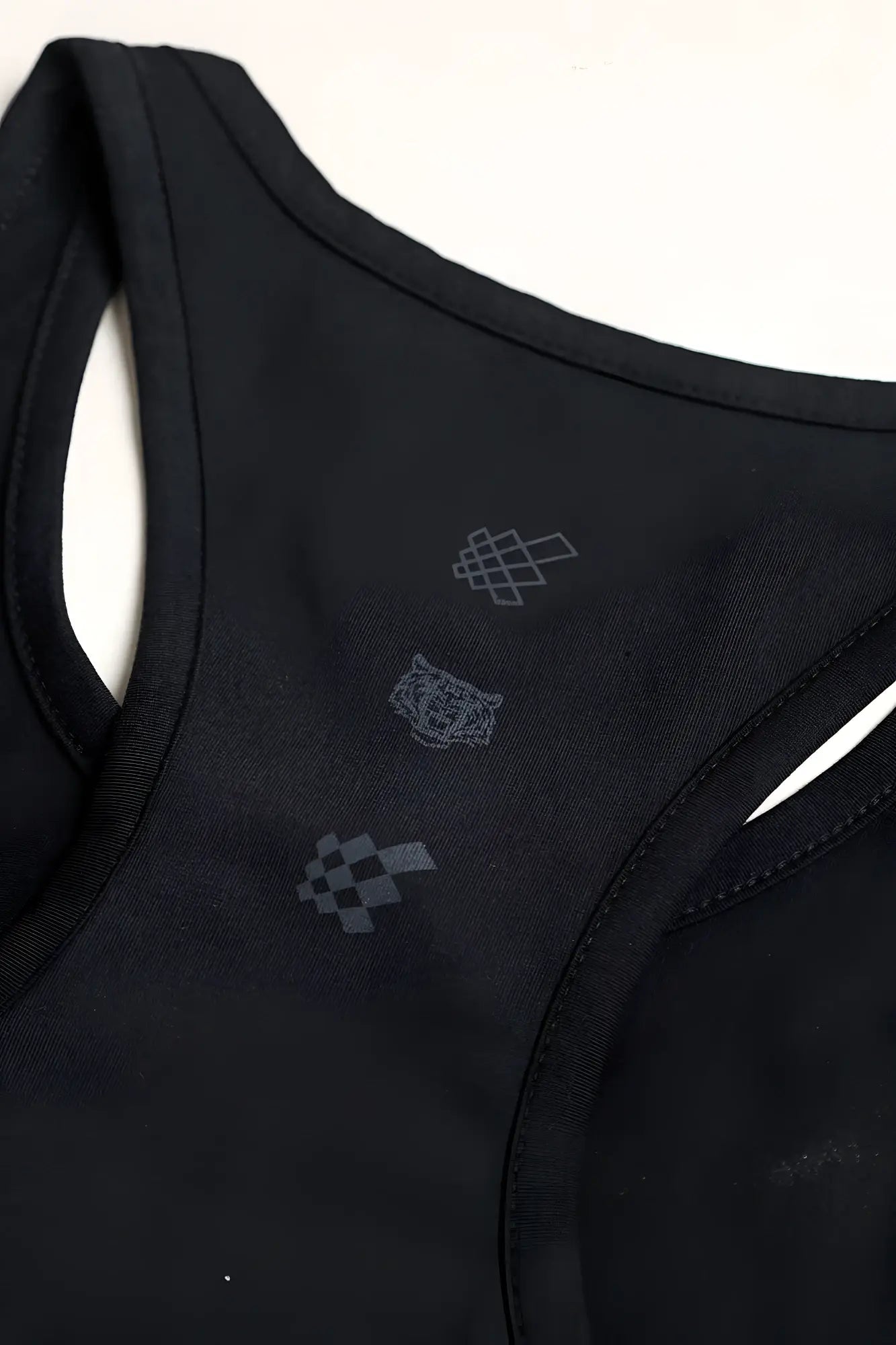 Black cotton training stringer tank top in midnight with racerback and subtle gray embroidered logos on the back side