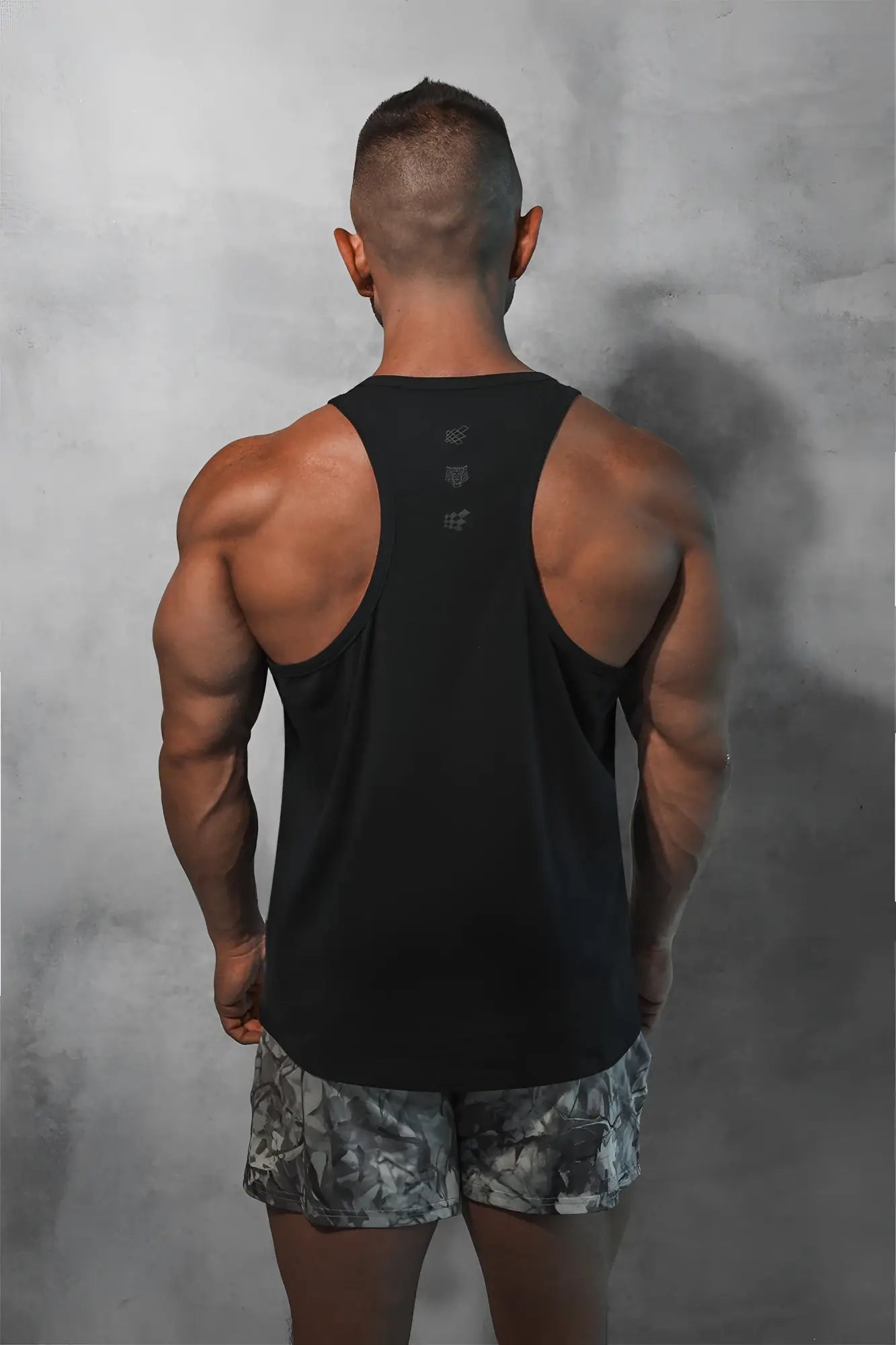 Black cotton training stringer sleeveless tank top with subtle logo detail on the back in midnight color