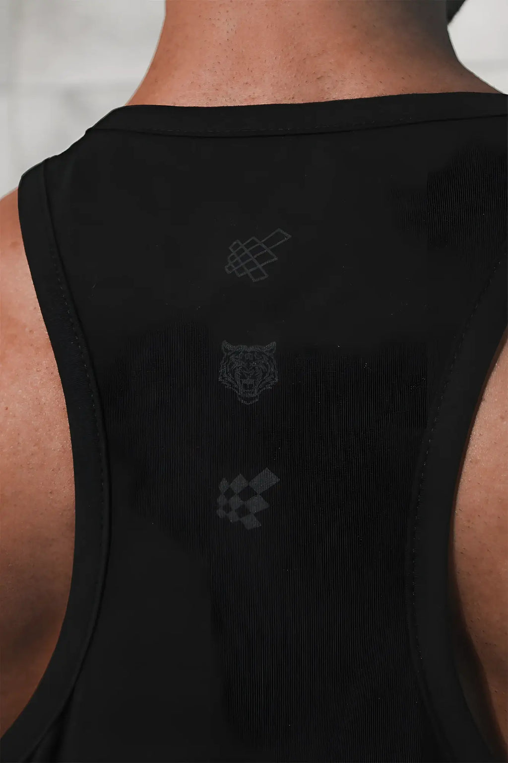 Black sleeveless cotton training stringer tank top with subtle gray embroidered logos on the back in midnight color