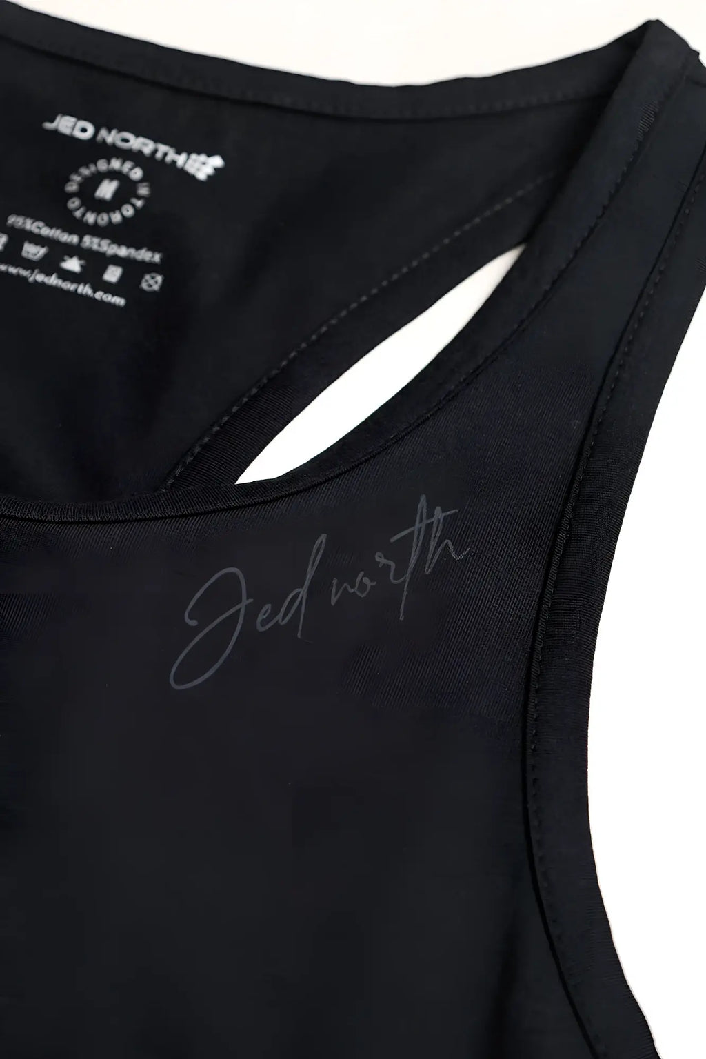 Black sleeveless cotton training stringer with stretchy fabric and subtle silver jed north logo embroidery