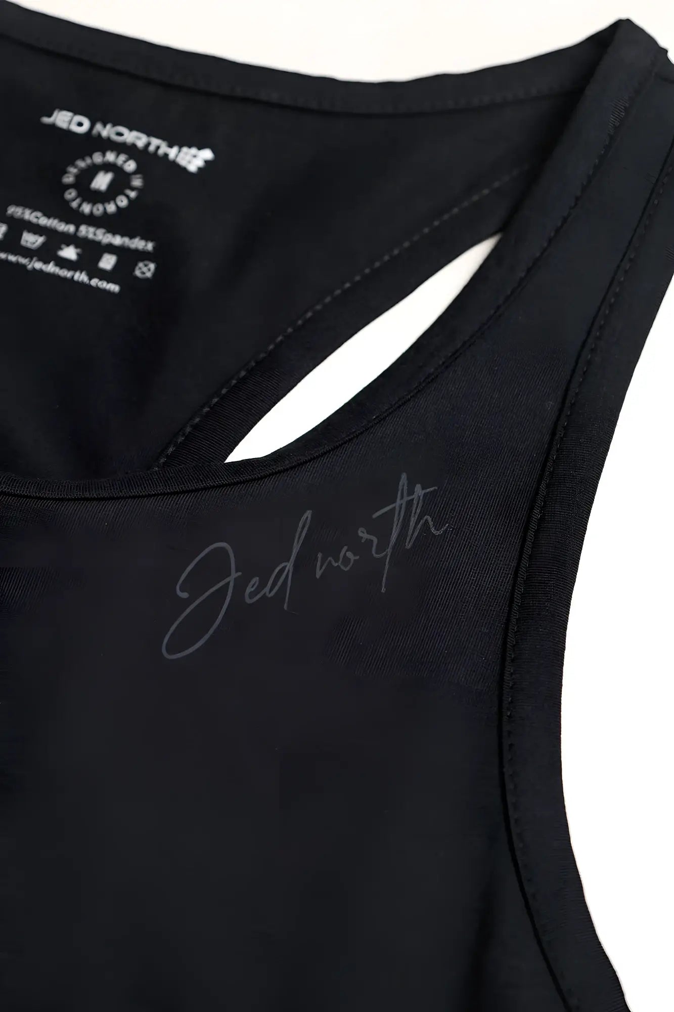 Black sleeveless cotton training stringer with stretchy fabric and subtle silver jed north logo embroidery