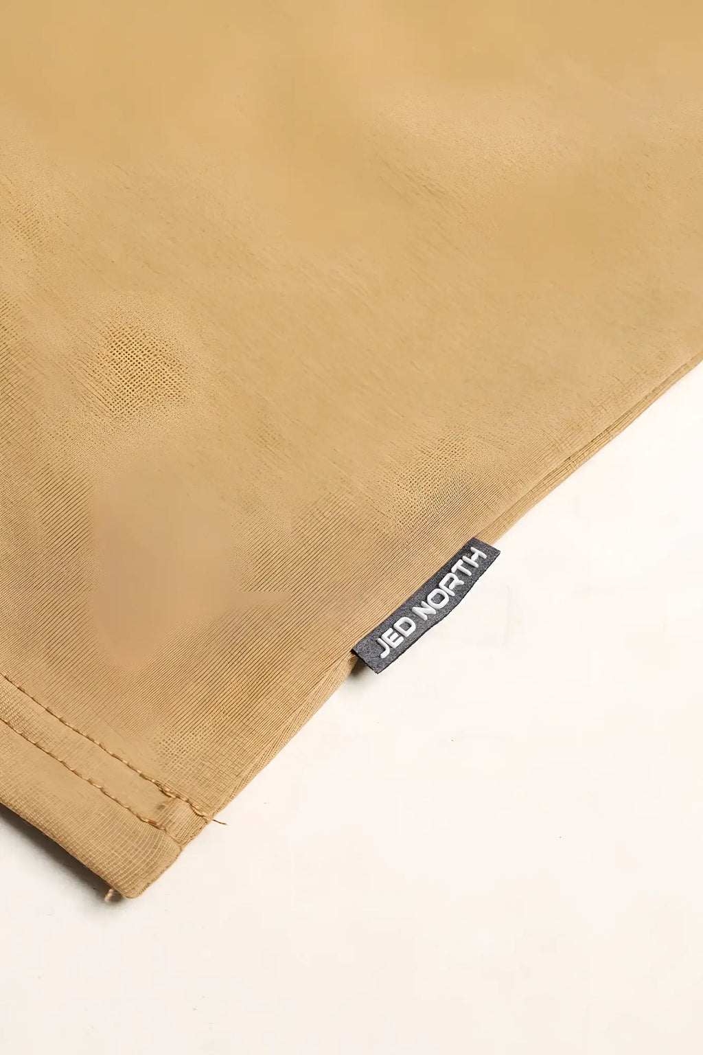 Tan cotton training stringer with black jed north brand tag stitched along the seam