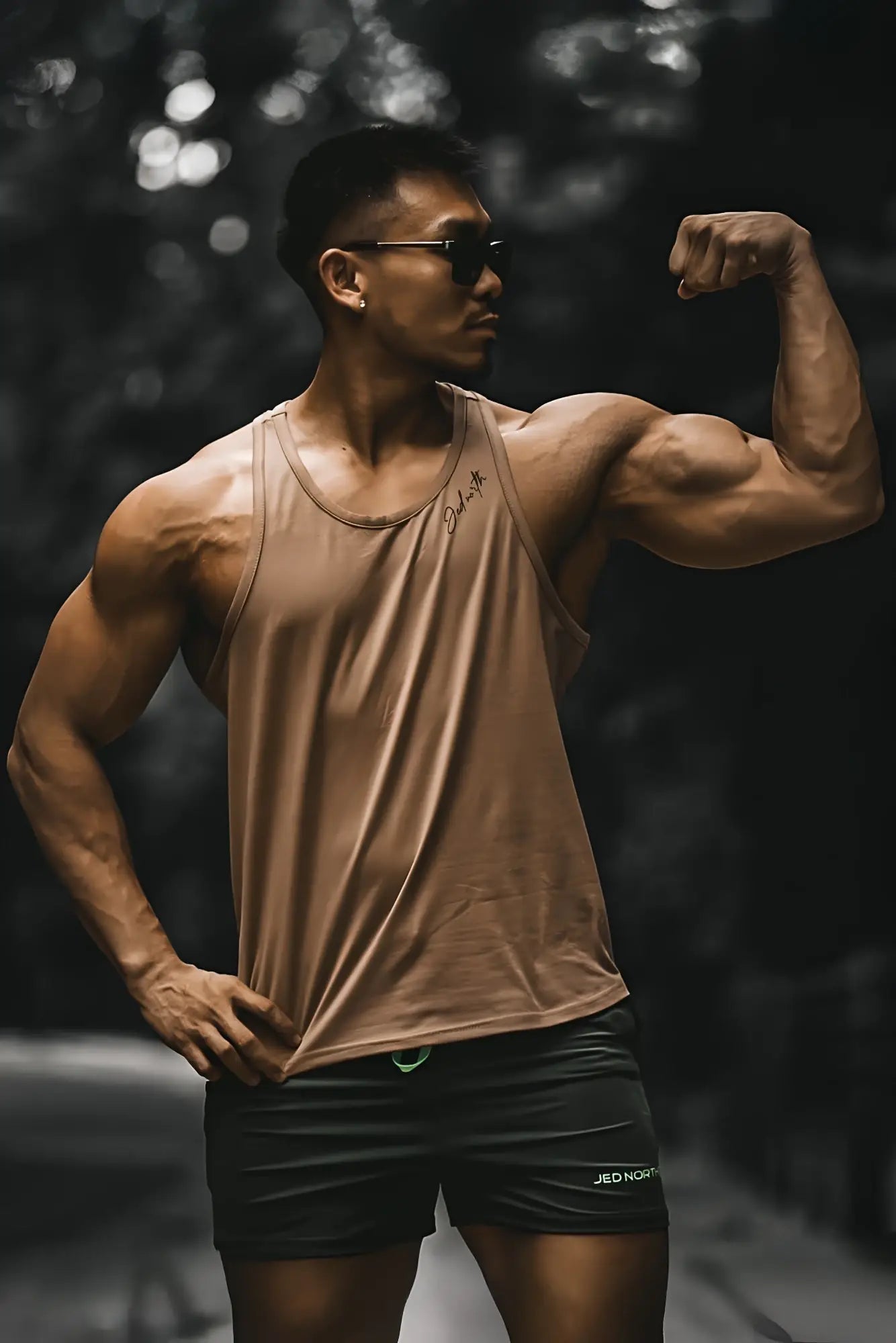 A tan cotton training stringer tank top with a sleeveless design and a subtle logo on the chest