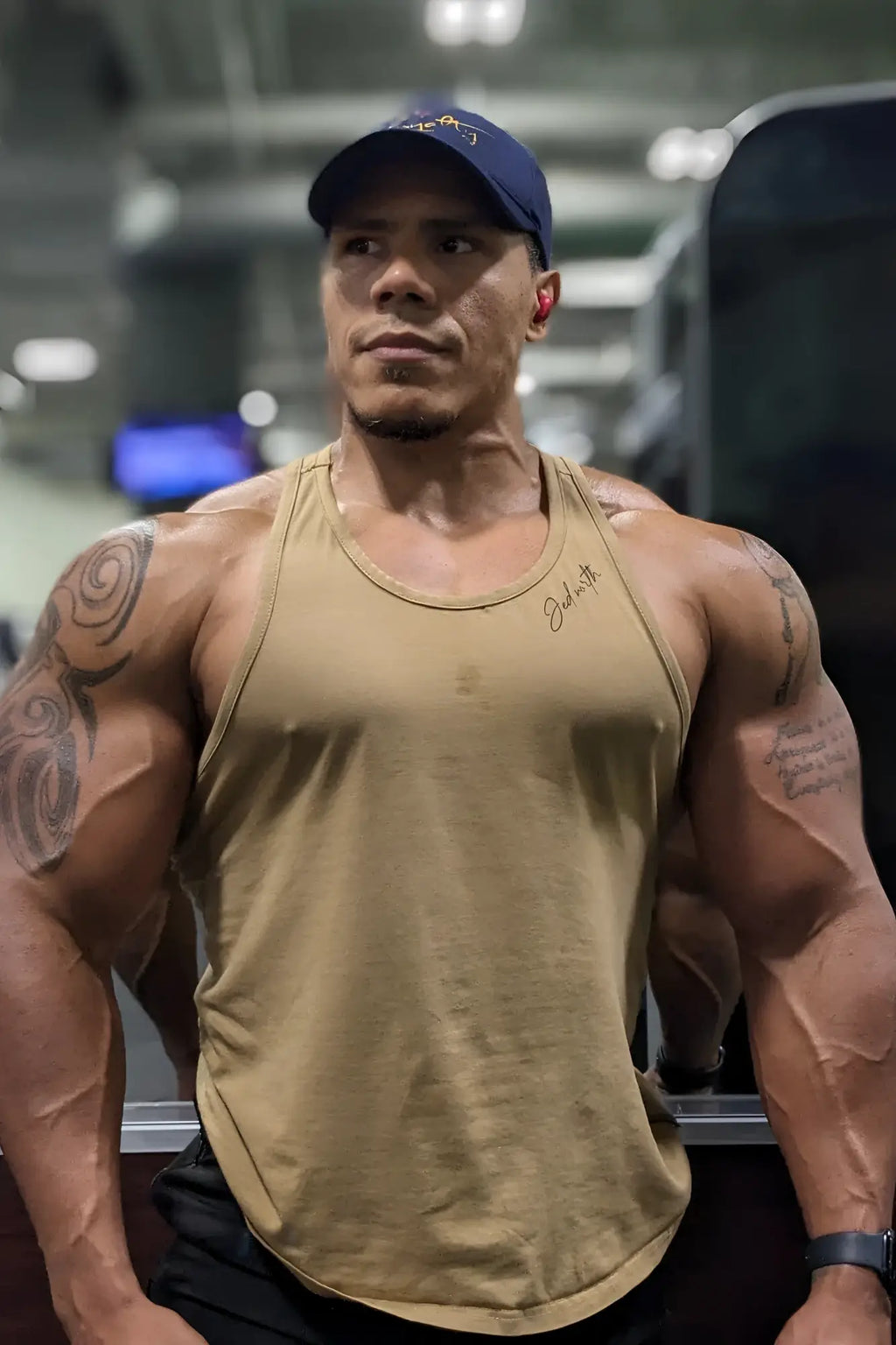 Tan cotton training stringer sleeveless athletic tank top with ribbed neckline and subtle chest signature