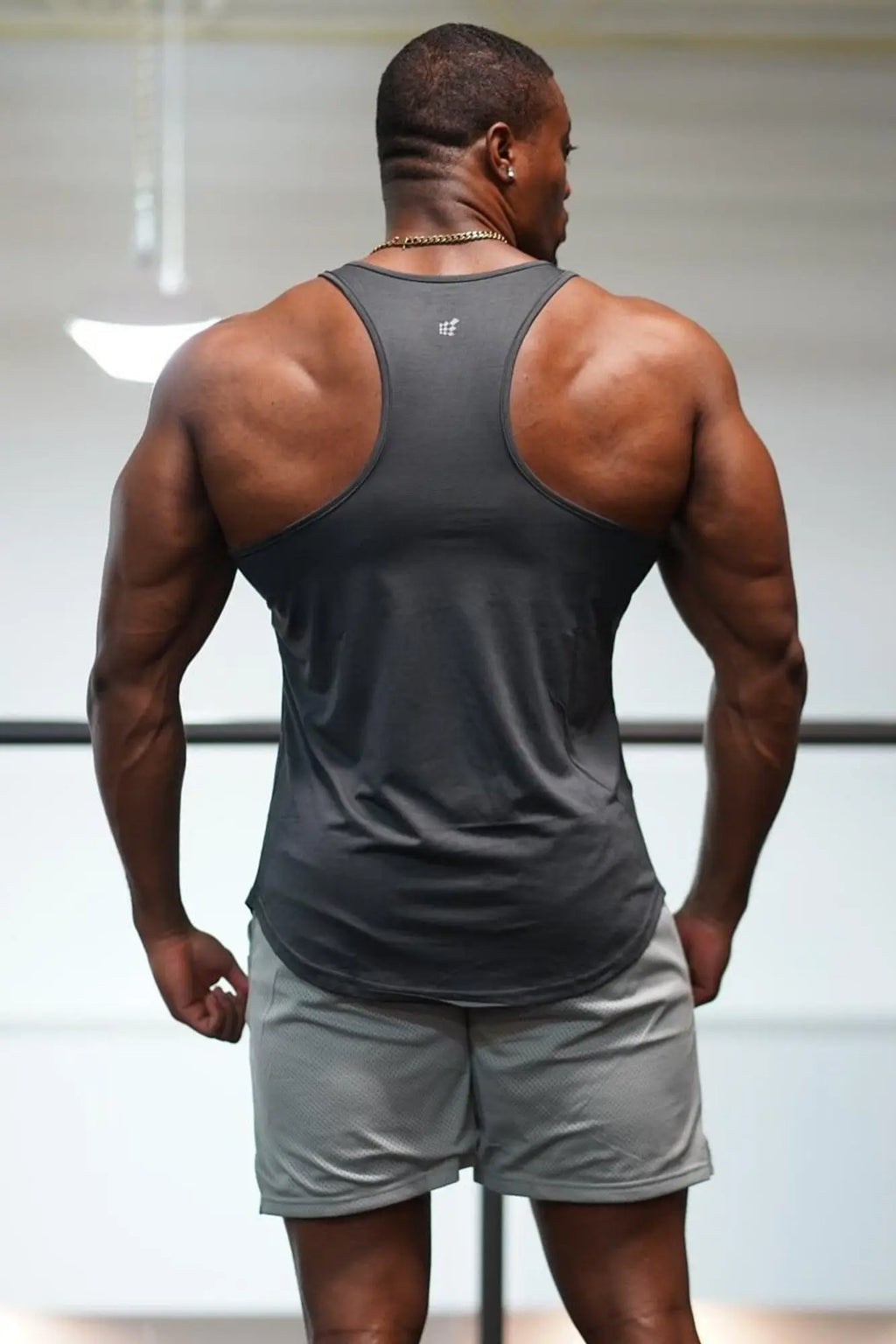 Back view of jed north dynamic bodybuilding stringer sleeveless athletic tank top in dark gray with subtle logo