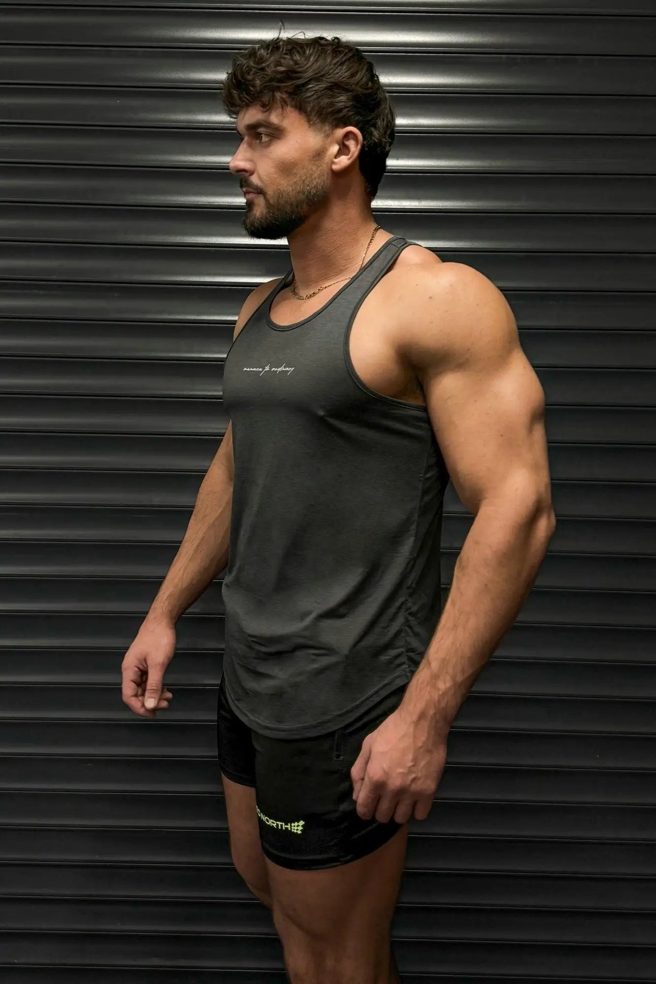 Dark gray sleeveless athletic tank top with subtle embroidered logo by Jed North for bodybuilding and training