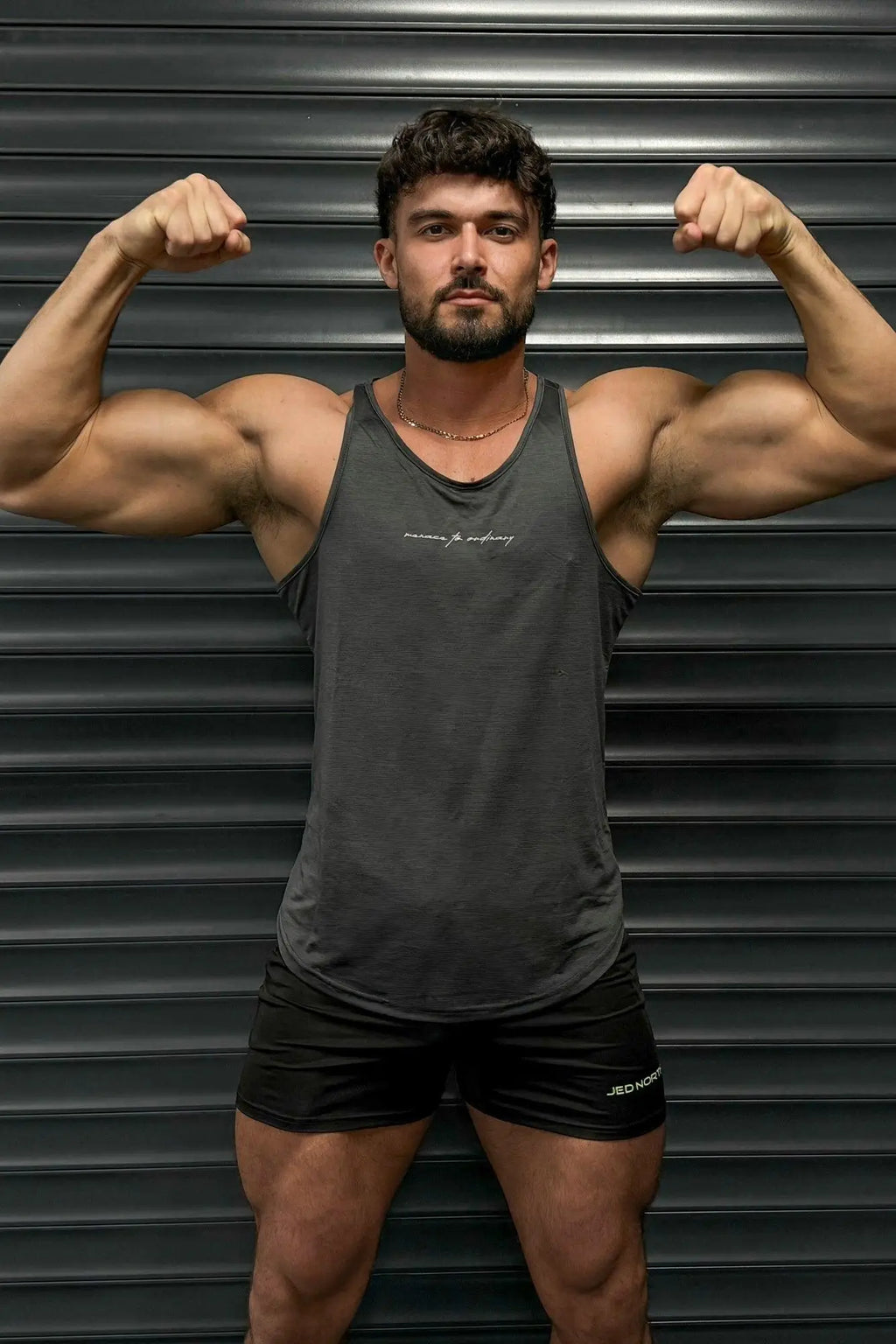 Dark gray Jed North dynamic bodybuilding stringer tank top with subtle white embroidered logo on chest