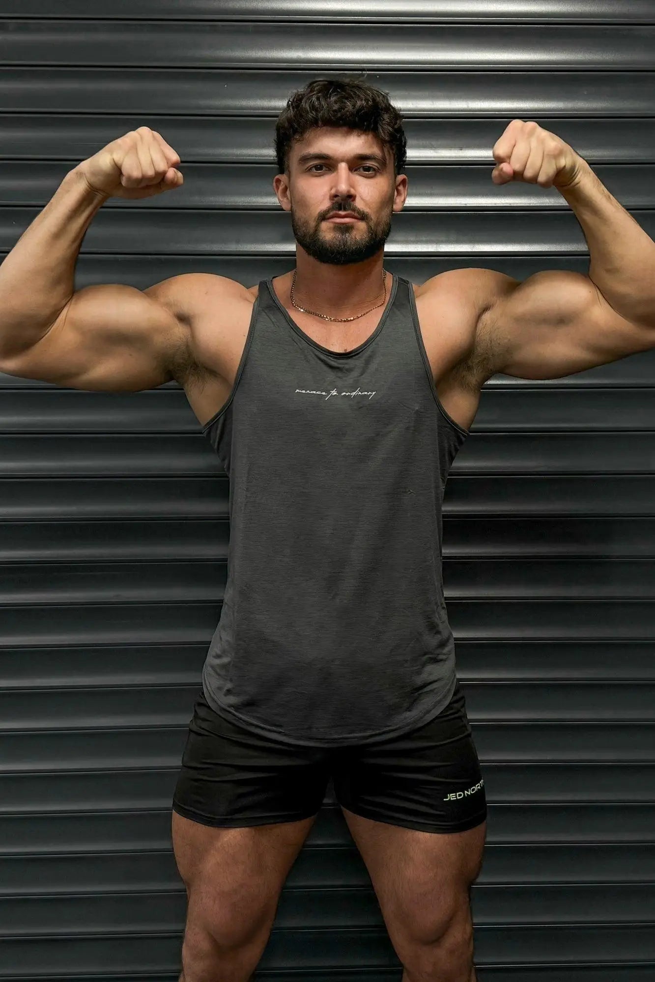 Dark gray Jed North dynamic bodybuilding stringer tank top with subtle white embroidered logo on chest