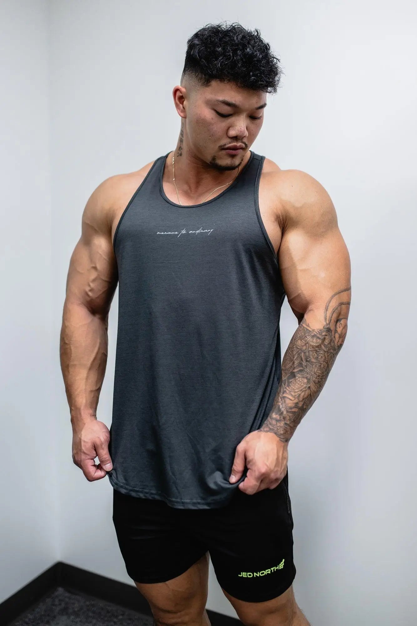 Jed North dynamic bodybuilding stringer sleeveless tank top in dark gray with subtle white cursive logo on chest