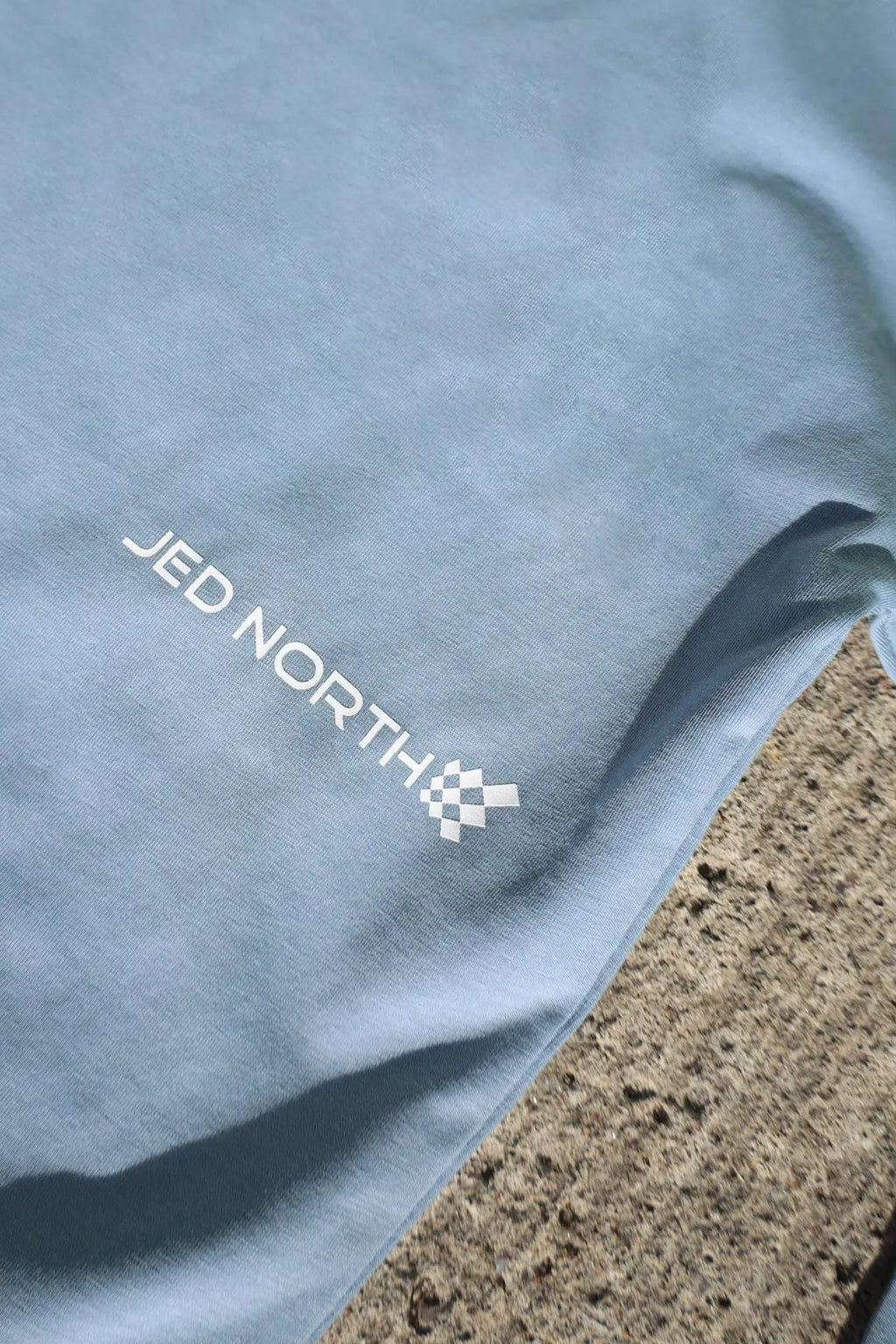 Light blue cotton jed north energy oversized long sleeve t-shirt 2.0 with white logo and checkered flag emblem