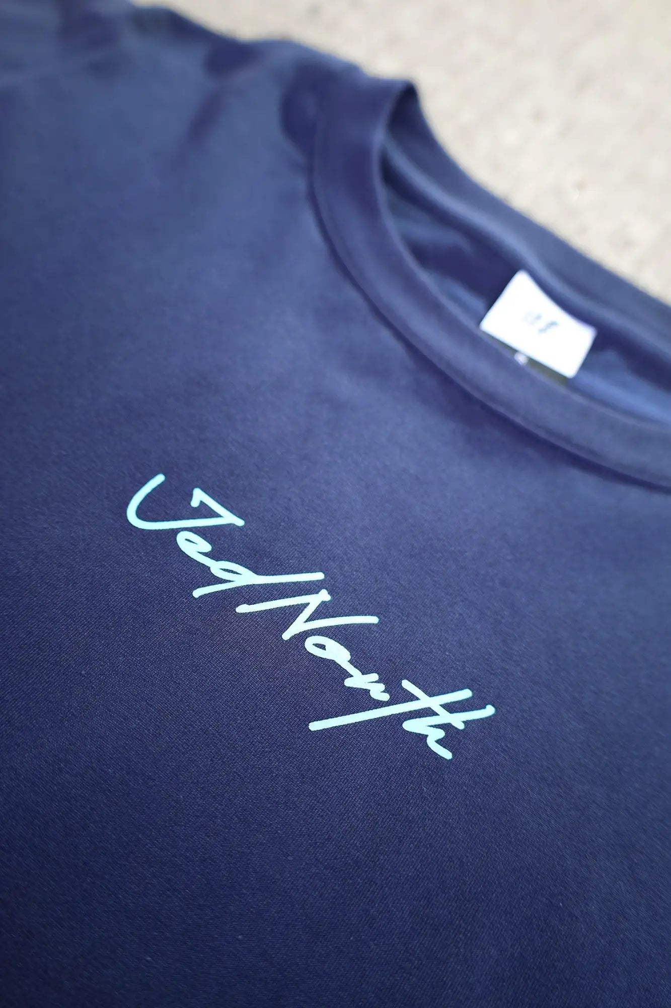 Dark blue jed north oversized crewneck t-shirt with light green vednorth cursive logo embroidered on chest